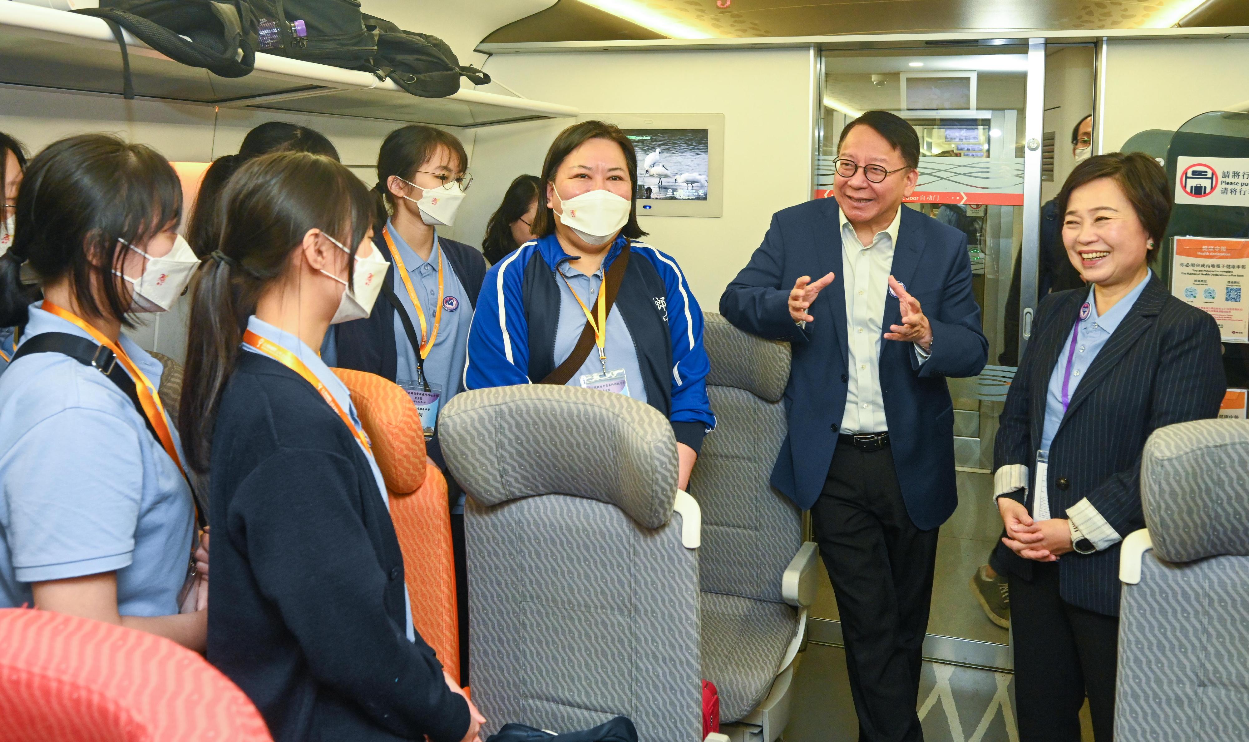 The delegation of the first Mainland study tour for students of the senior secondary subject of Citizenship and Social Development set off this morning (April 3) by the Guangzhou-Shenzhen-Hong Kong Express Rail Link for a two-day trip to Guangzhou and Shenzhen. Photo shows the Chief Secretary for Administration, Mr Chan Kwok-ki (second right), and the Secretary for Education, Dr Choi Yuk-lin (first right), chatting with the participating students and teachers.