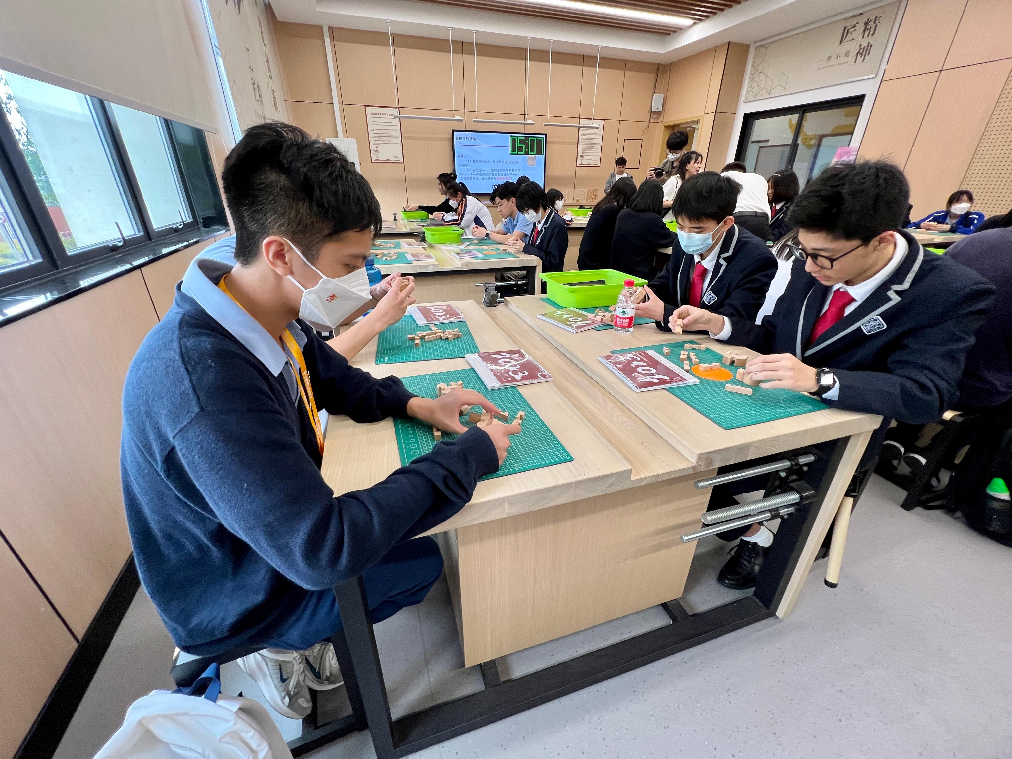 The delegation of the first Mainland study tour for students of the senior secondary subject of Citizenship and Social Development visited Guangzhou ZhiXin High School today (April 3). Photo shows members of the delegation joining students of ZhiXin High School in a woodwork class.
