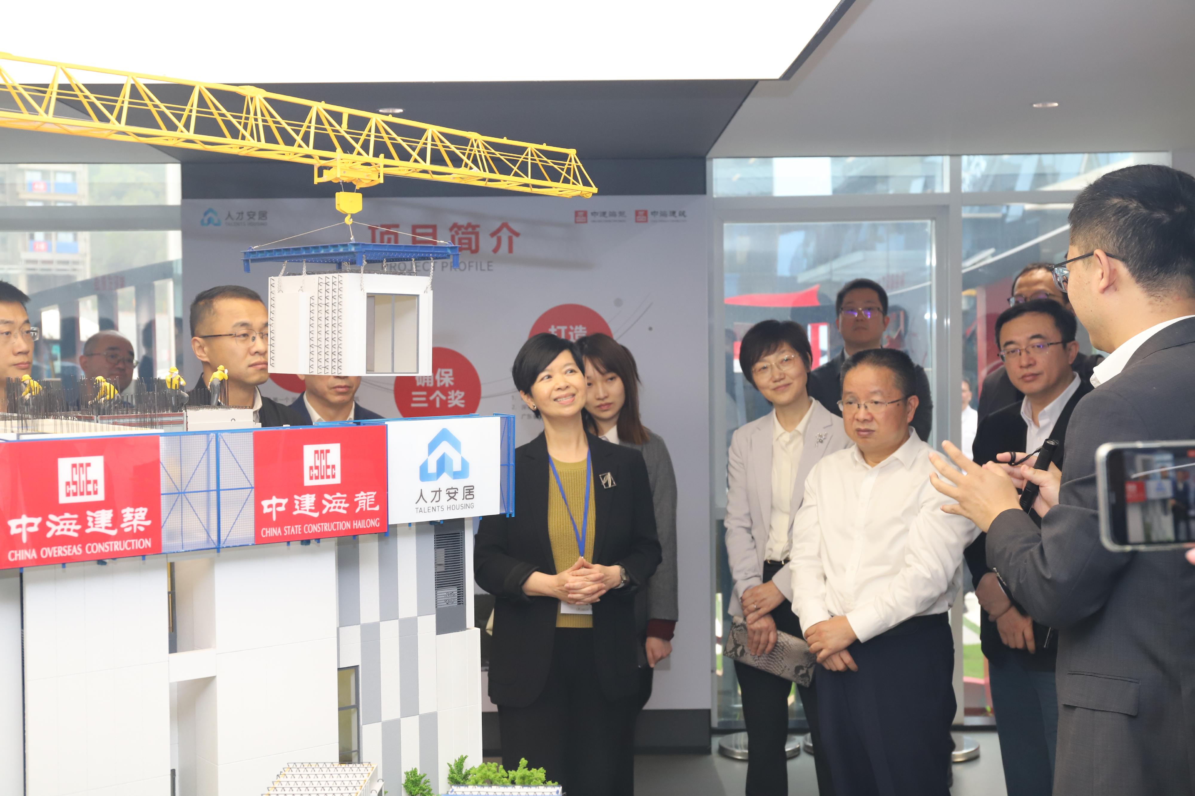 The Secretary for Housing, Ms Winnie Ho, led representatives of the Housing Bureau, the Housing Department and the Architectural Services Department to Shenzhen today (April 3). Photo shows Ms Ho (first left) visiting an indemnificatory housing project in Zhangkeng, Longhua District, and being briefed on the project which was built expeditiously by adopting the Modular Integrated Construction method as a concrete construction approach.