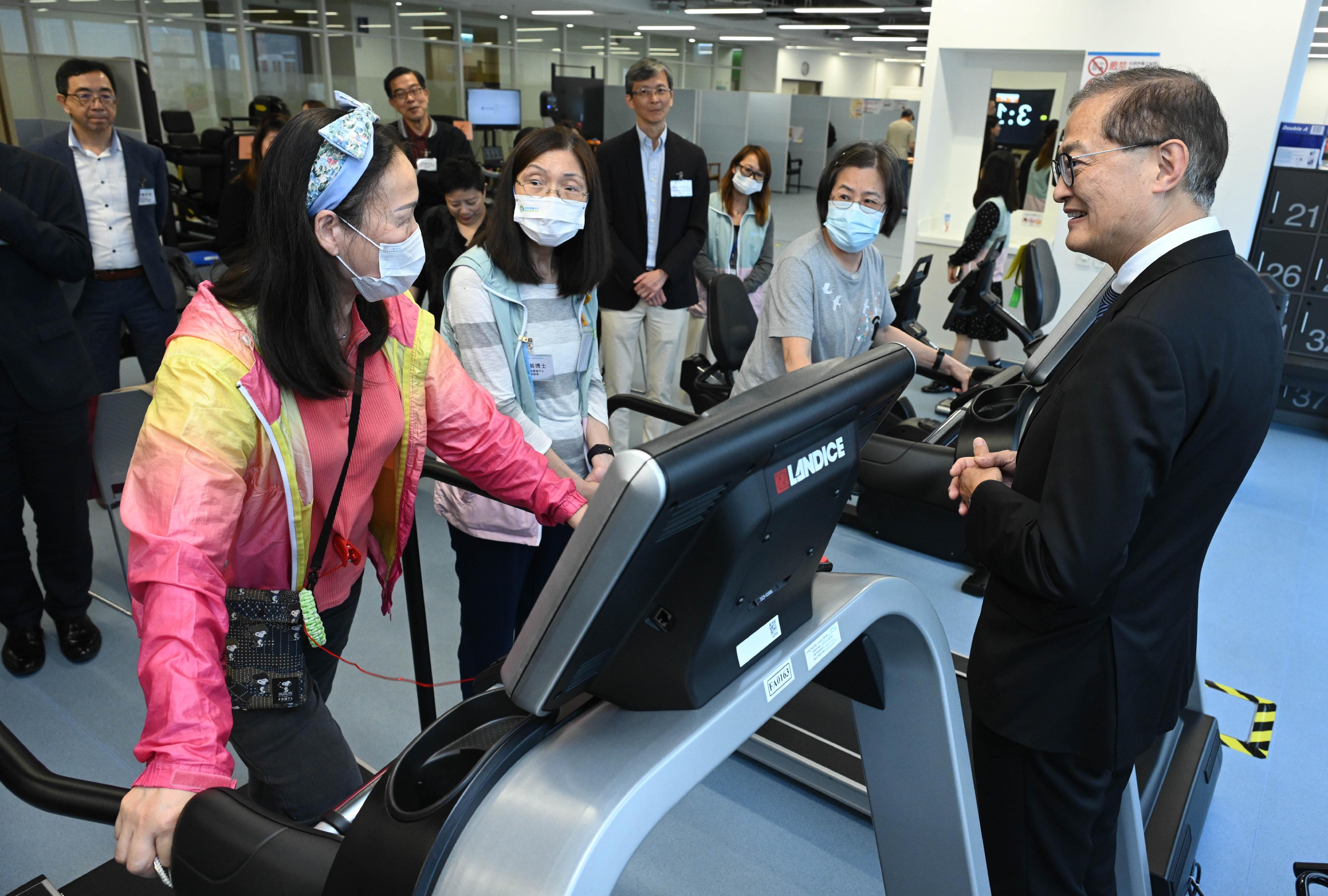 医务卫生局局长卢宠茂教授（右一）今日（四月四日）下午到访葵青地区康健中心，并与康复室的使用者交流。