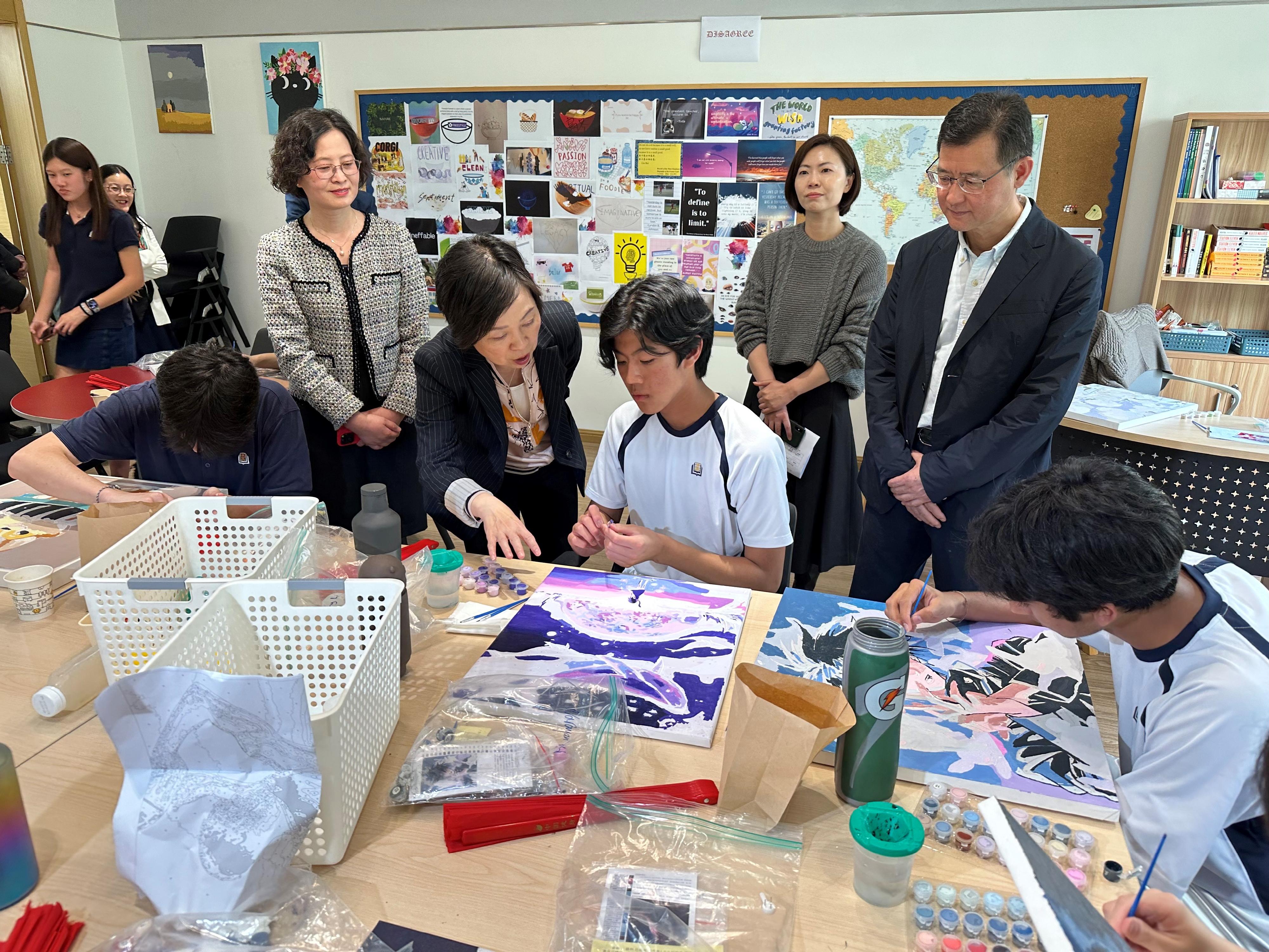 教育局局長蔡若蓮博士今日（四月十一日）到訪杭州漢基外籍人員子女學校。圖示蔡若蓮博士（前排左二）與一名學生交談。