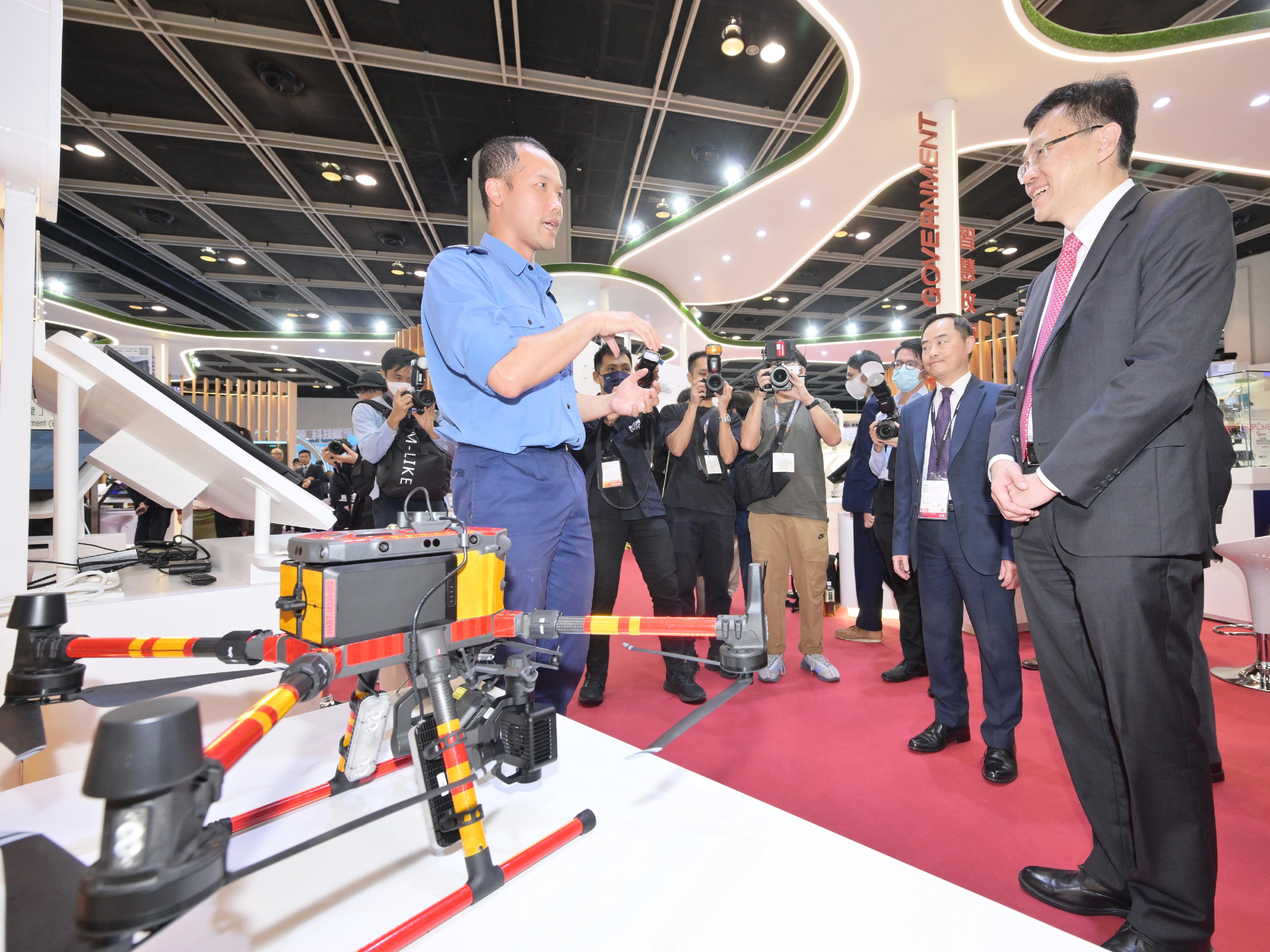 The Secretary for Innovation, Technology and Industry, Professor Sun Dong (first right), visited the Smart Hong Kong Pavilion at InnoEX today (April 12) and was briefed on the Hong Kong Fire Services Department's Unmanned Aircraft System. Looking on is the Acting Government Chief Information Officer, Mr Tony Wong (second right).