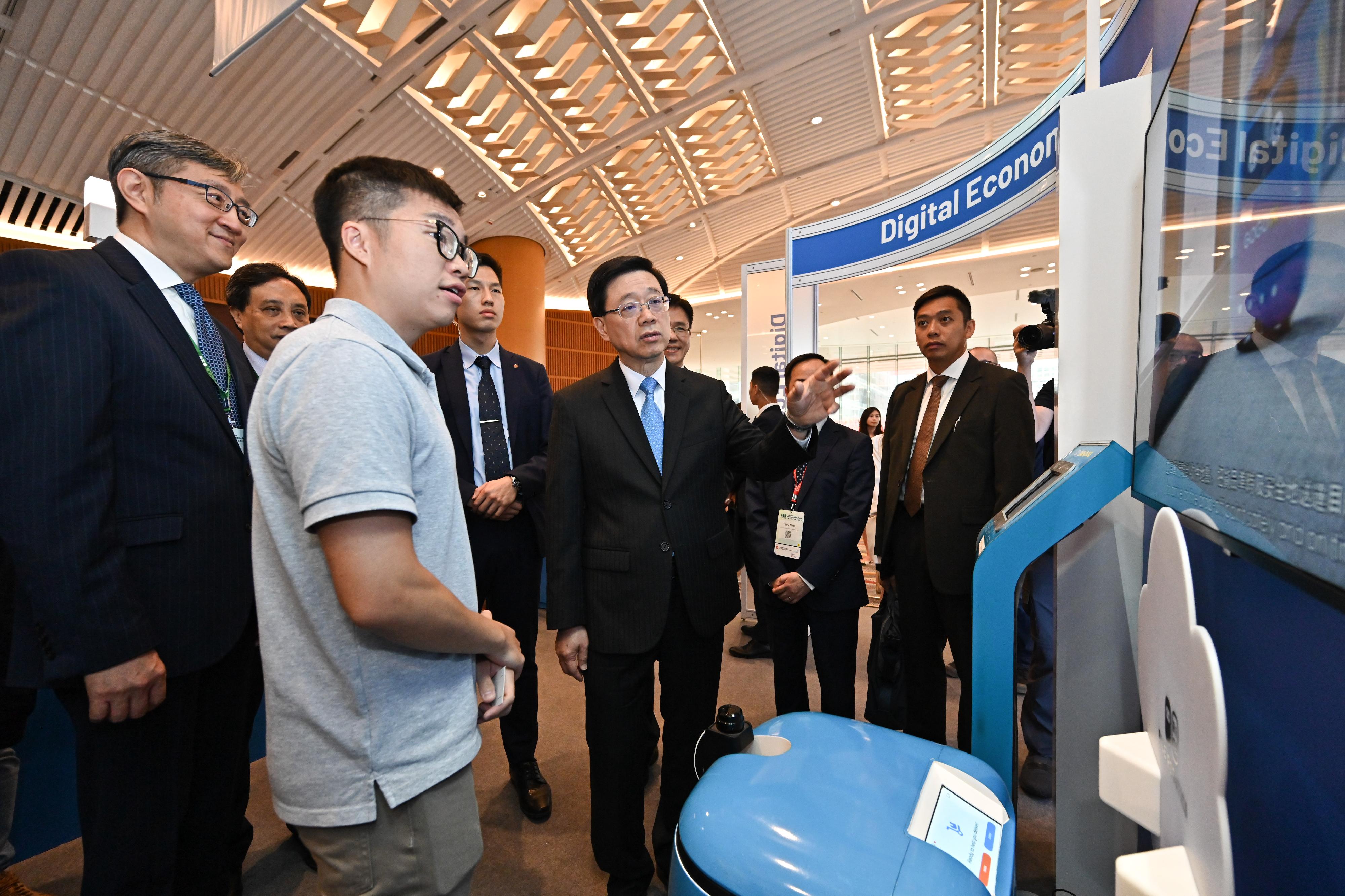 The Chief Executive, Mr John Lee (third left), tours the exhibition before the Digital Economy Summit 2023 today (April 13).