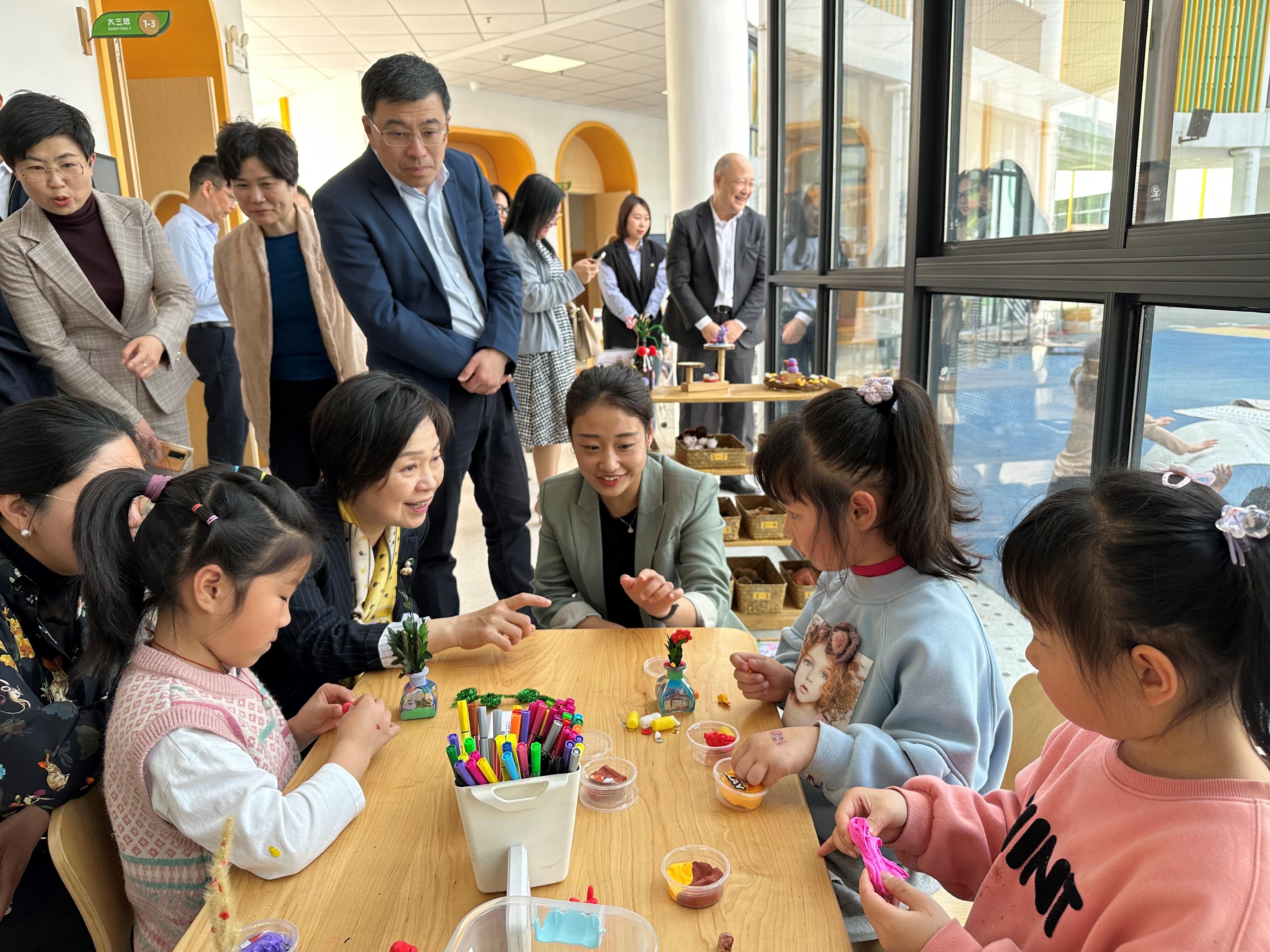教育局局長蔡若蓮博士昨日（四月十二日）到訪位於浙江省湖州市的安吉縣機關幼兒園。圖示蔡若蓮博士（前排左三）觀察學童從遊戲中學習。