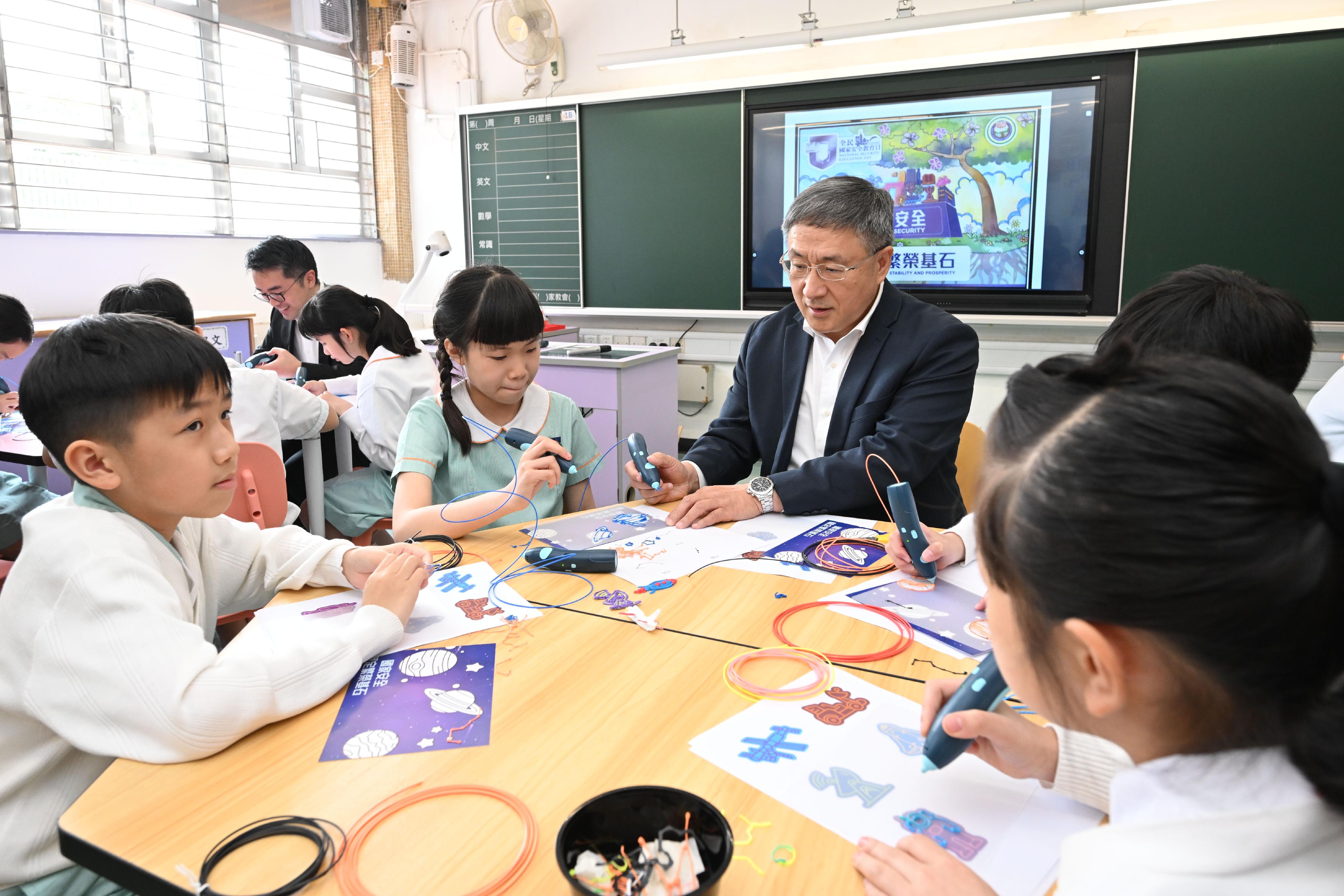 The Deputy Chief Secretary for Administration, Mr Cheuk Wing-hing, takes part in a workshop on 3D printing with students at Shatin Government Primary School today (April 13).