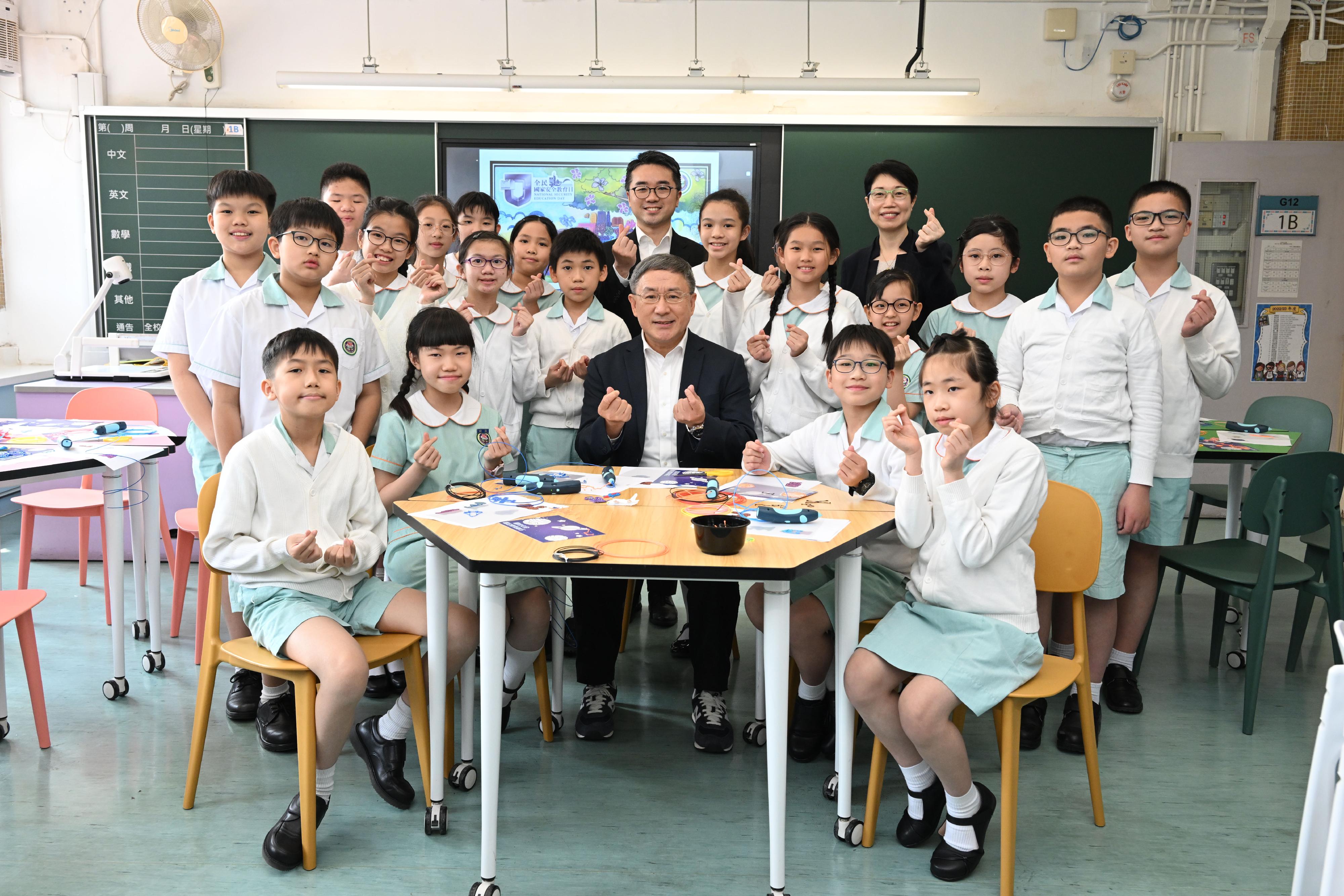 The Deputy Chief Secretary for Administration, Mr Cheuk Wing-hing (front row, centre), and the Acting Secretary for Education, Mr Sze Chun-fai (back row, centre), join a group photo with the students and the school principal of Shatin Government Primary School, Ms Ellen Wong (back row, fourth right), after visiting a workshop on 3D printing today (April 13).