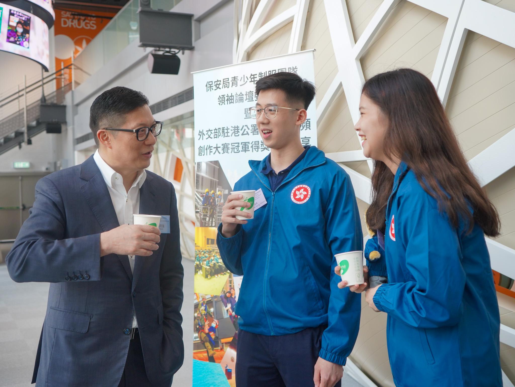 The Secretary for Security, Mr Tang Ping-keung, today (April 14) presented appointment certificates to the Security Bureau Youth Uniformed Group Leaders Forum Advisory Board and congratulated youth members on winning first prize of video contest. Photo shows Mr Tang (first left) exchanging views with the two youth members who won the first prize.     