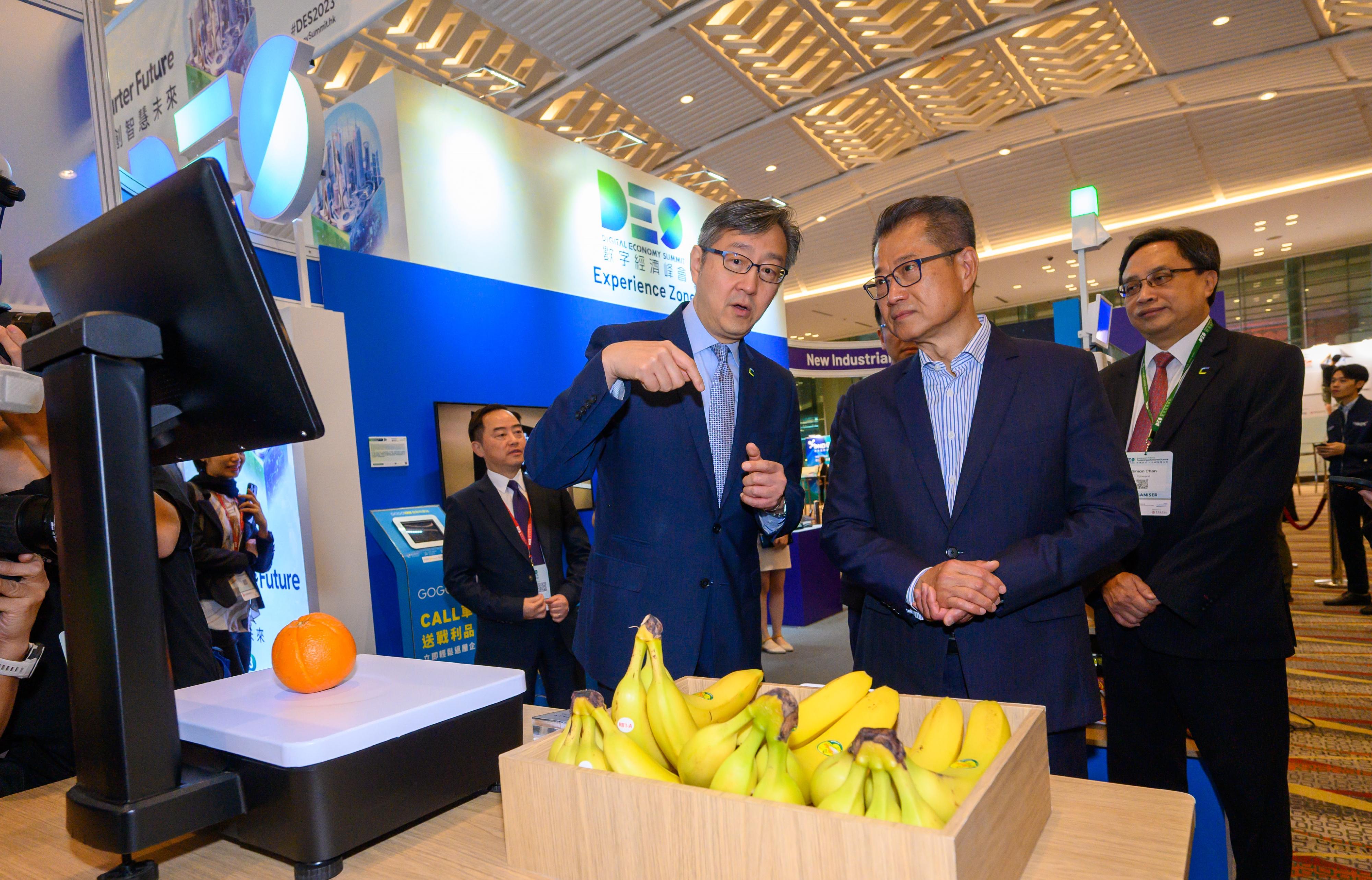The Financial Secretary, Mr Paul Chan (second right), tours the exhibition before attending the FinTech Forum of the Digital Economy Summit 2023 today (April 14). 