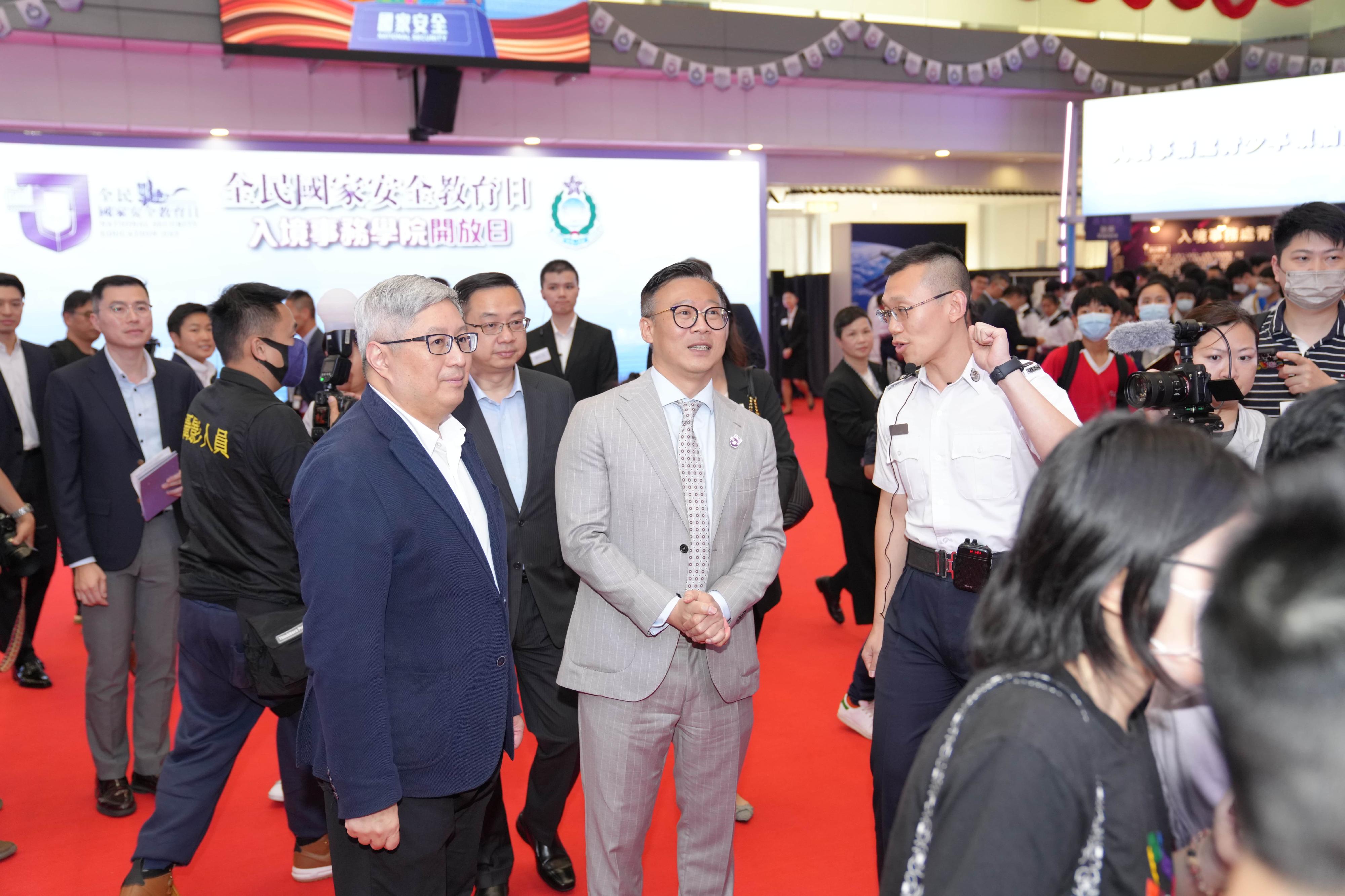 To support the National Security Education Day, the Immigration Service Institute of Training and Development held an open day today (April 15). Photo shows the Deputy Secretary for Justice, Mr Cheung Kwok-kwan (front row, centre), accompanied by the Director of Immigration, Mr Au Ka-wang (front row, left), visiting an exhibition booth.