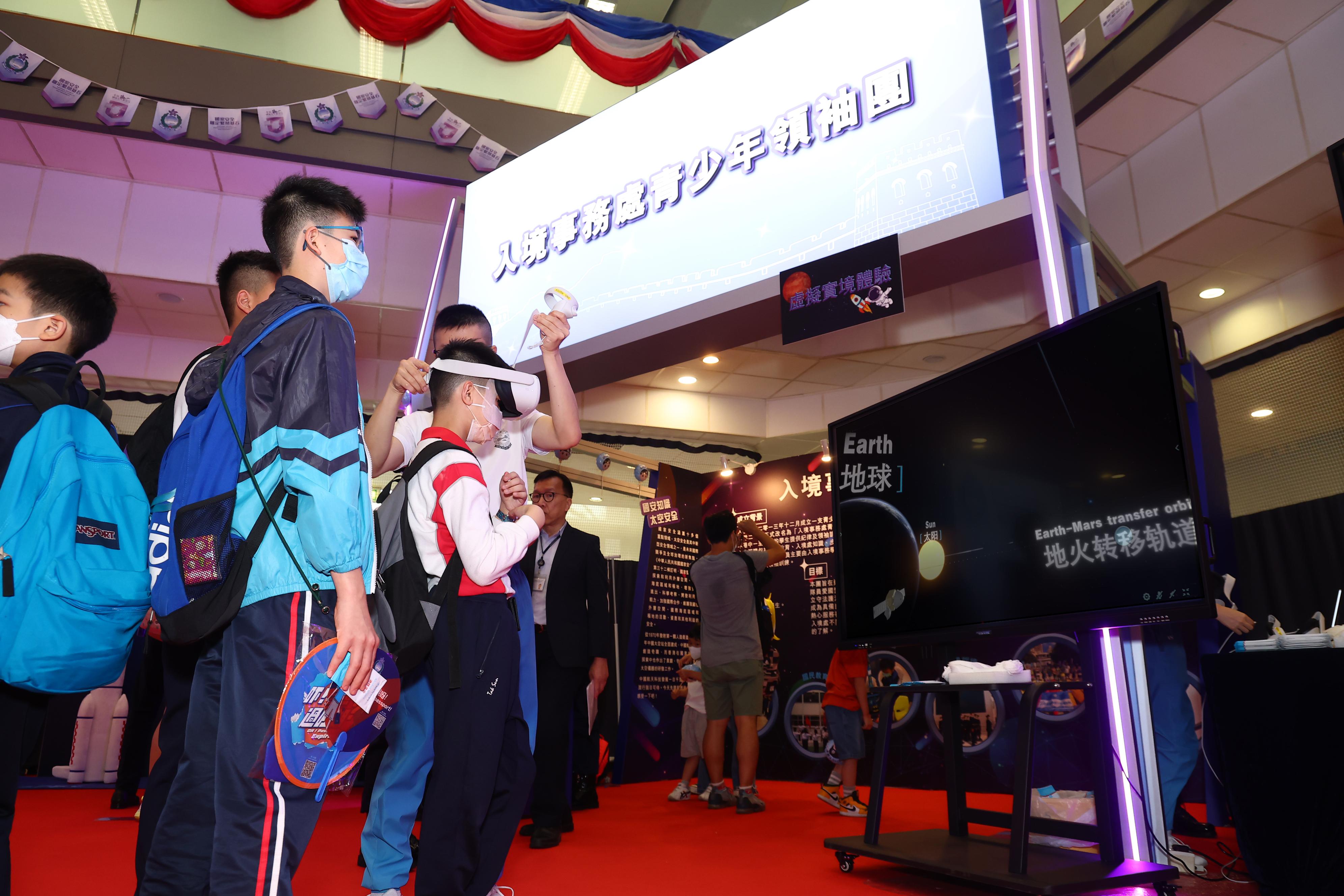 To support the National Security Education Day, the Immigration Service Institute of Training and Development held an open day today (April 15). Photo shows the members of the Immigration Department Youth Leaders Corps were assisting members of the public to experience virtual reality in the major field of "outer space security".