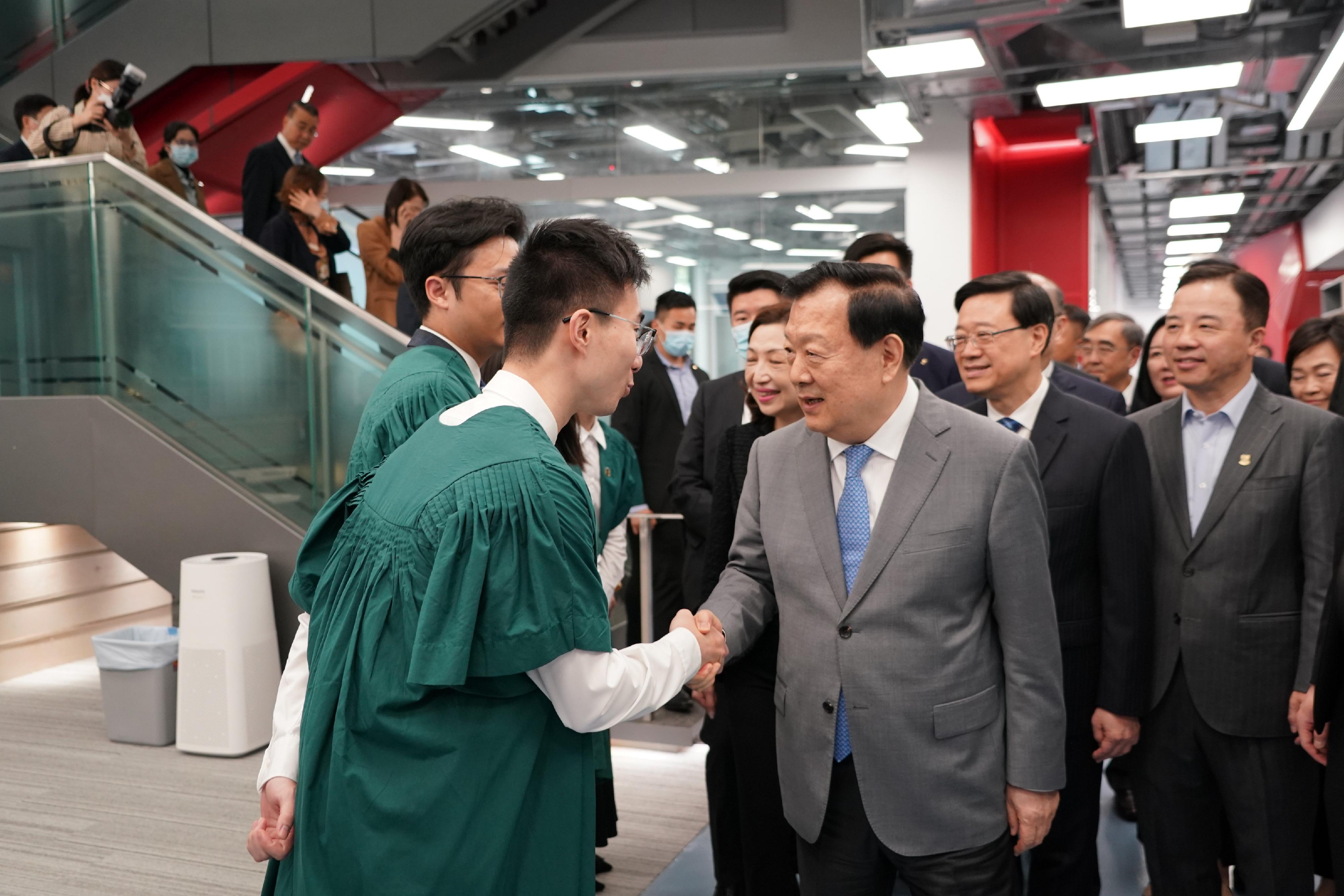 The Vice Chairman of the 13th Chinese People's Political Consultative Conference and Director of the Hong Kong and Macao Affairs Office of the State Council, Mr Xia Baolong (third right), accompanied by the Chief Executive, Mr John Lee (second right), visited the University of Hong Kong on April 18. Photo shows Mr Xia interacting with students.