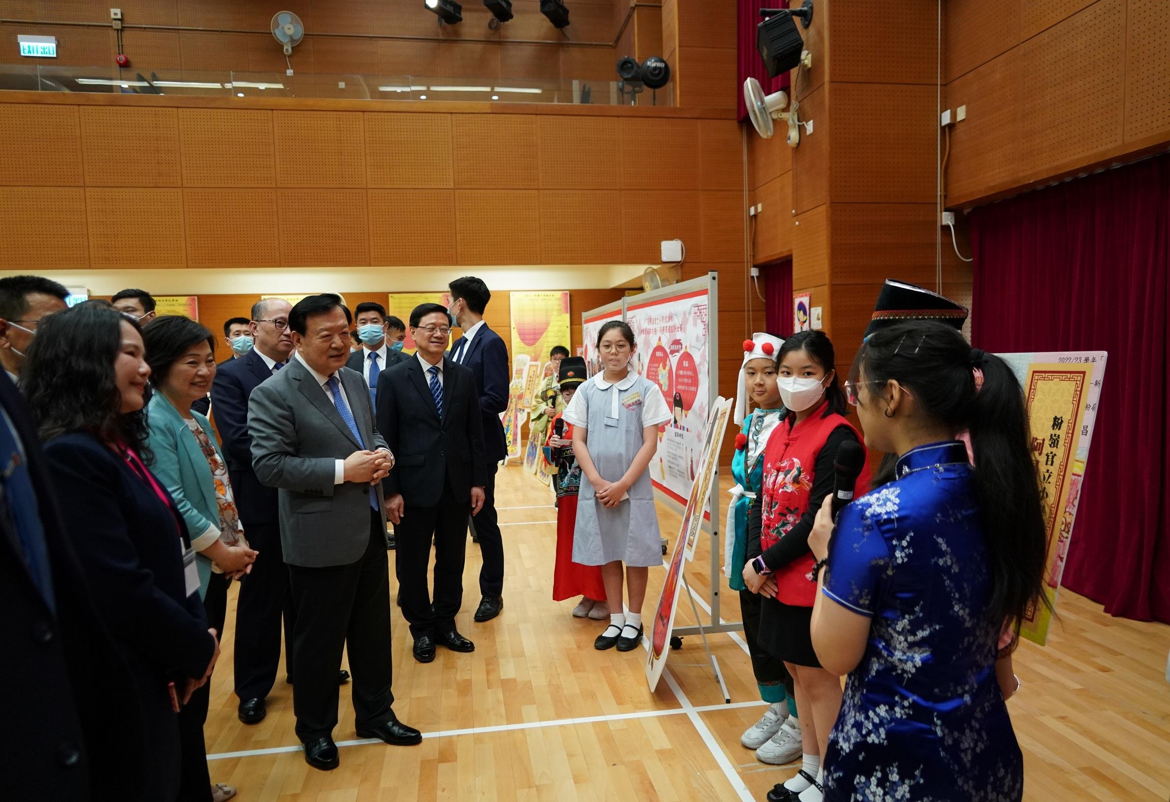 The Vice Chairman of the 13th Chinese People's Political Consultative Conference and Director of the Hong Kong and Macao Affairs Office of the State Council, Mr Xia Baolong (third left), accompanied by the Chief Executive, Mr John Lee (fourth left), and the Secretary for Education, Dr Choi Yuk-lin (second left), visited Ma Tau Chung Government Primary School (Hung Hom Bay) on April 18. Photo shows Mr Xia listening to students' sharing on their learning experience.