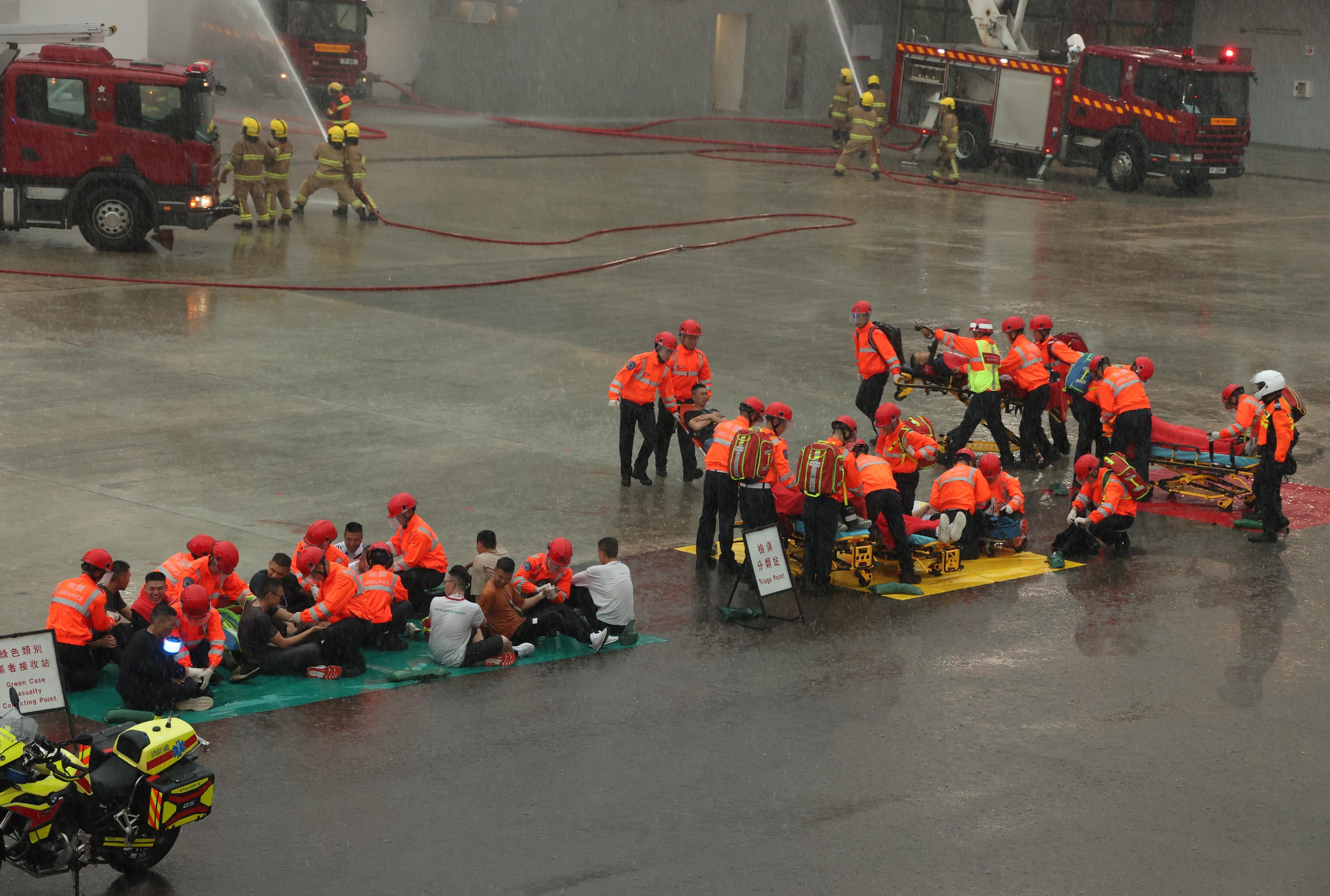 The Chief Executive, Mr John Lee, reviewed the Fire Services passing-out parade at the Fire and Ambulance Services Academy today (April 19). Photo shows graduates demonstrating firefighting and rescue techniques.