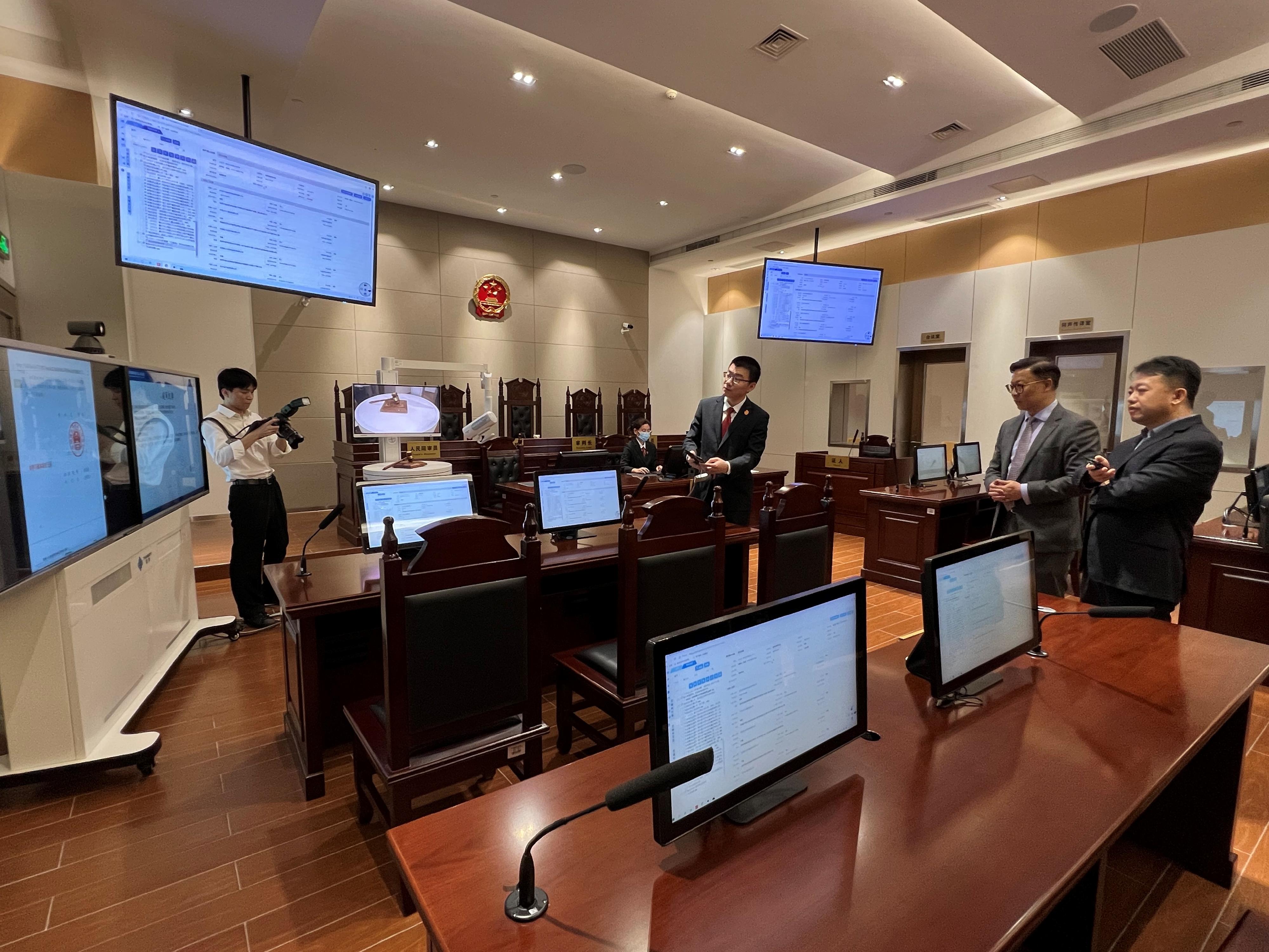 The Deputy Secretary for Justice, Mr Cheung Kwok-kwan (second right), visited the Shenzhen Qianhai Cooperation Zone People's Court in Shenzhen today (April 19), and was briefed by its President, Mr Bian Fei (first right), on the latest situation of the Court's application of technology.
