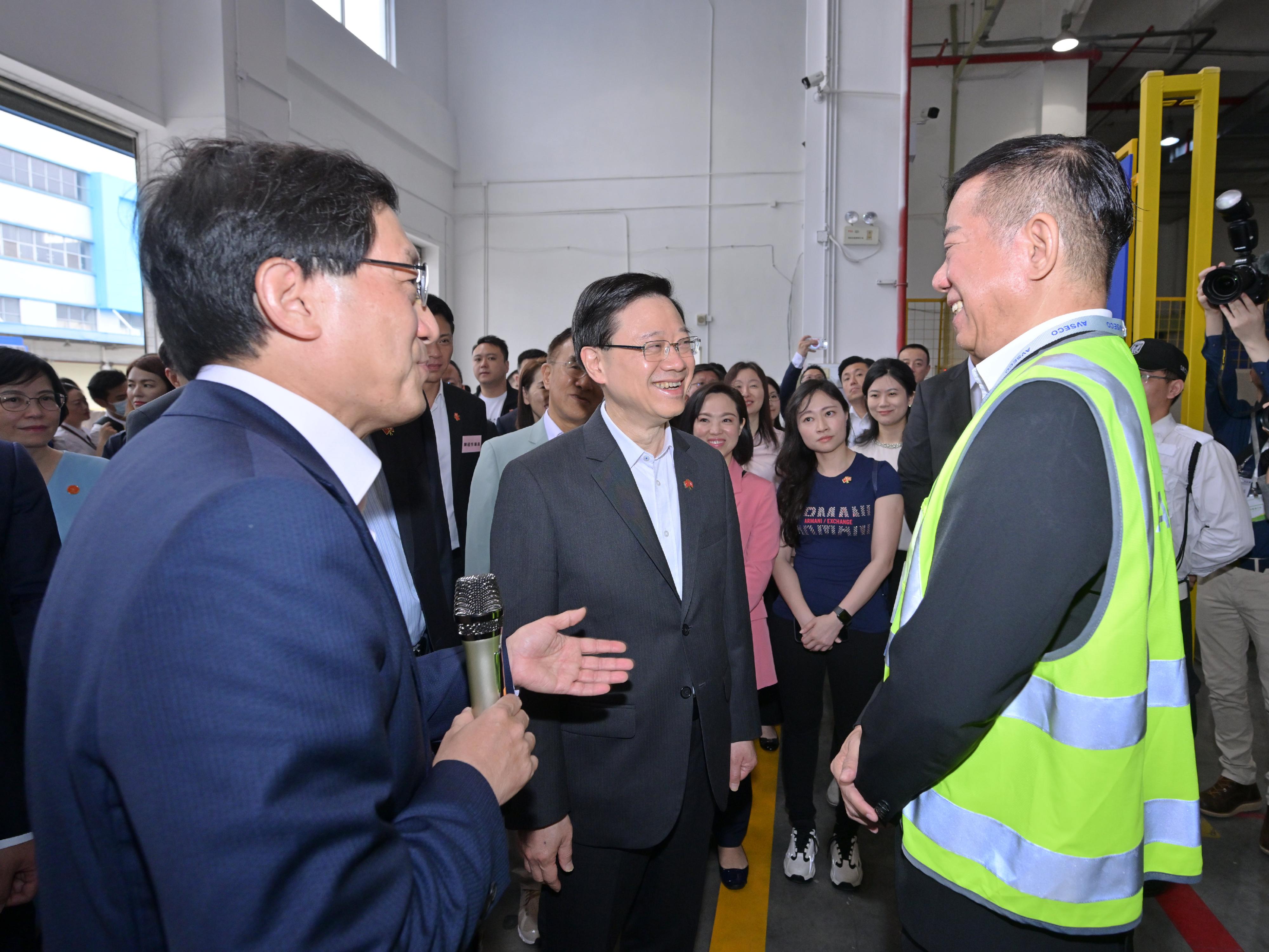 The Chief Executive, Mr John Lee, led a delegation of the Hong Kong Special Administrative Region Government and the Legislative Council to visit Dongguan today (April 23). Photo shows Mr Lee (centre), visiting the Dongguan Hong Kong International Airport Logistics Park and listening to the introduction of the operation of the regulated air cargo screening facility by the Chief Executive Officer of the Airport Authority Hong Kong, Mr Fred Lam (left).