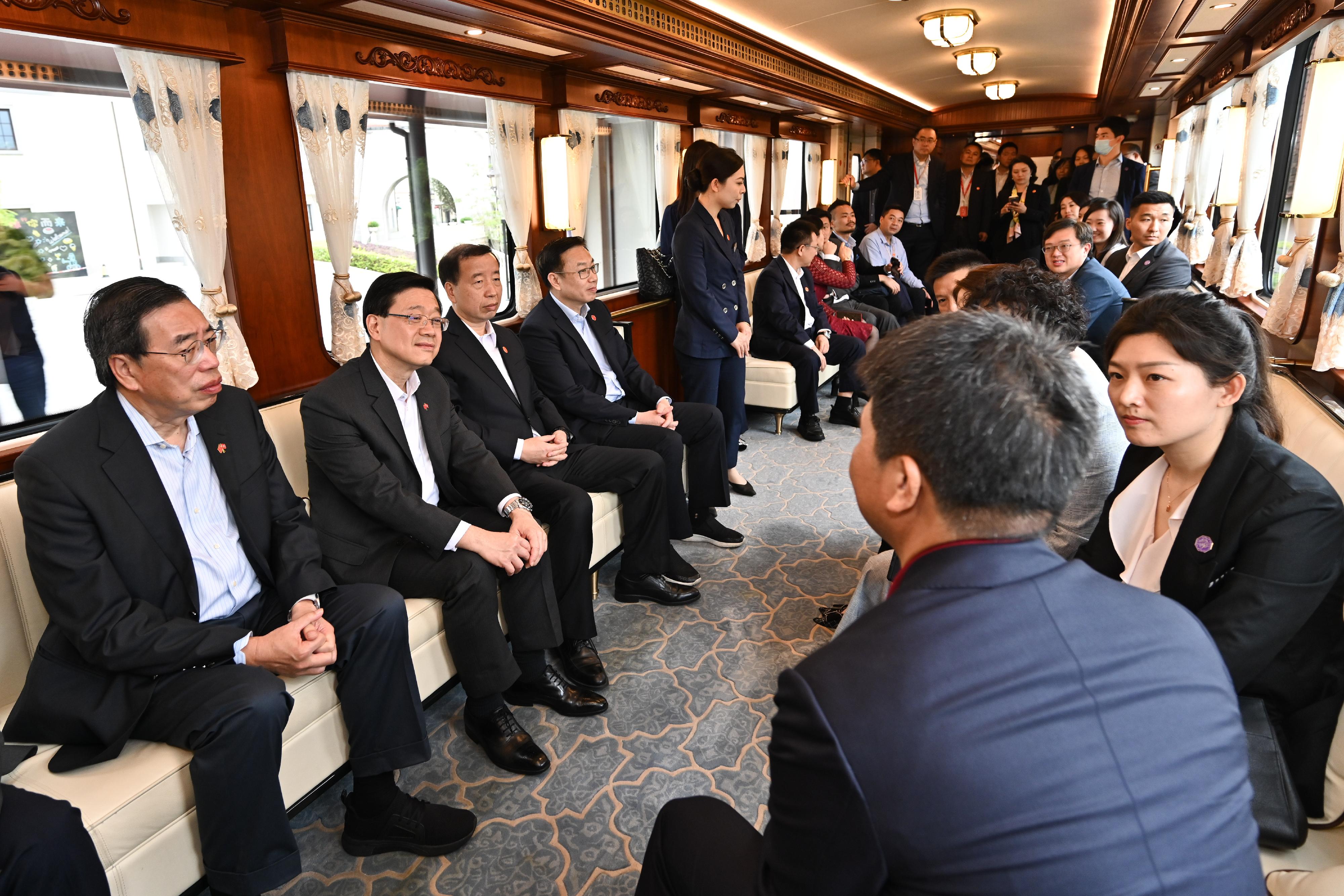The Chief Executive, Mr John Lee, led a delegation of the Hong Kong Special Administrative Region Government and Legislative Council (LegCo) to visit Dongguan today (April 23). Photo shows (from left) the President of the LegCo, Mr Andrew Leung; Mr Lee; the Secretary of the CPC Dongguan Municipal Committee, Mr Xiao Yafei, and Deputy Director of the Liaison Office of the Central People's Government in the Hong Kong Special Administrative Region Mr He Jing, visiting the Huawei Ox Horn Campus by a small train.