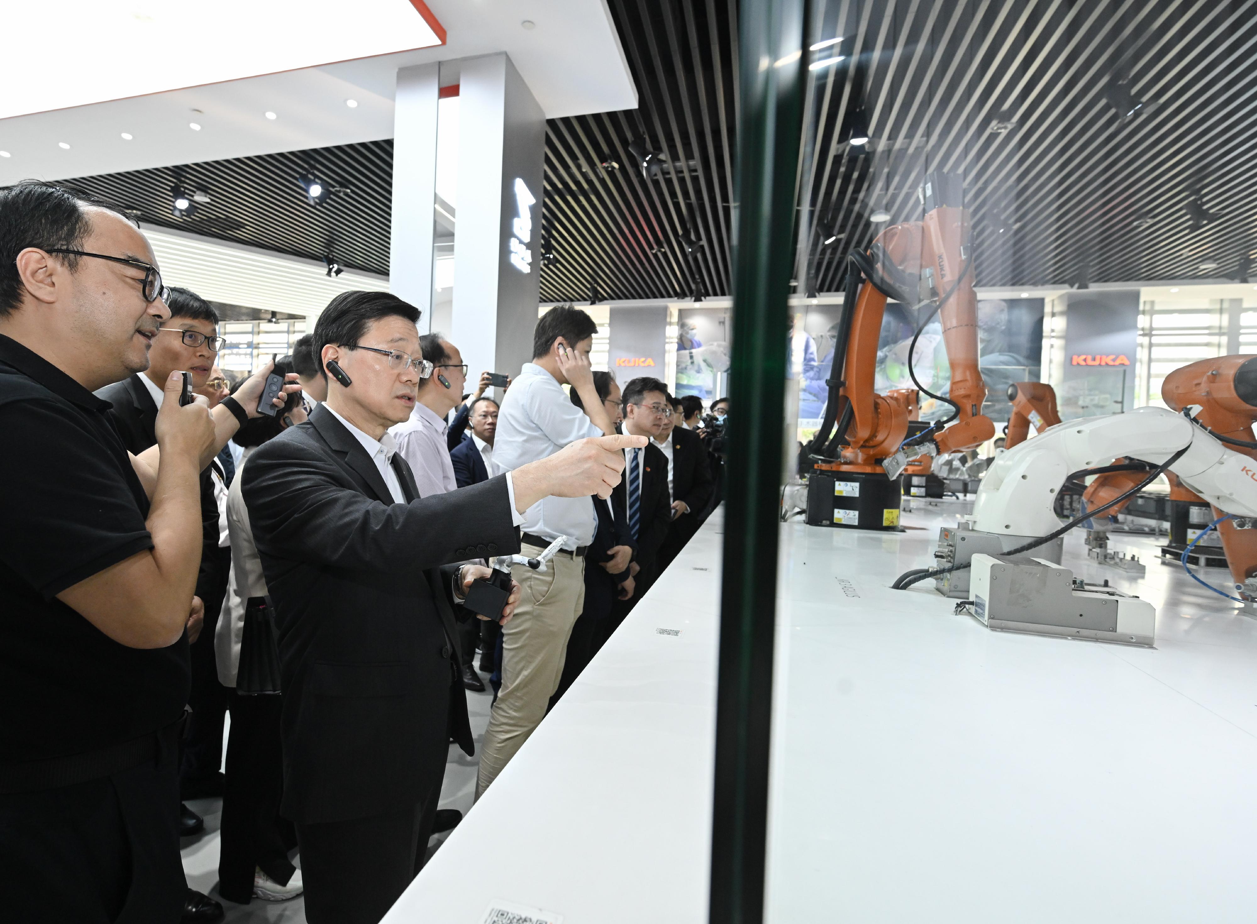 The delegation of the Hong Kong Special Administrative Region Government and the Legislative Council (LegCo) led by the Chief Executive, Mr John Lee, conducted their third-day visit in the Guangdong-Hong Kong-Macao Greater Bay Area today (April 23). Photo shows Mr Lee (second left) receiving a briefing by a representative of the KUKA Robotics Guangdong Co., Ltd. on the operation of robotic arm.