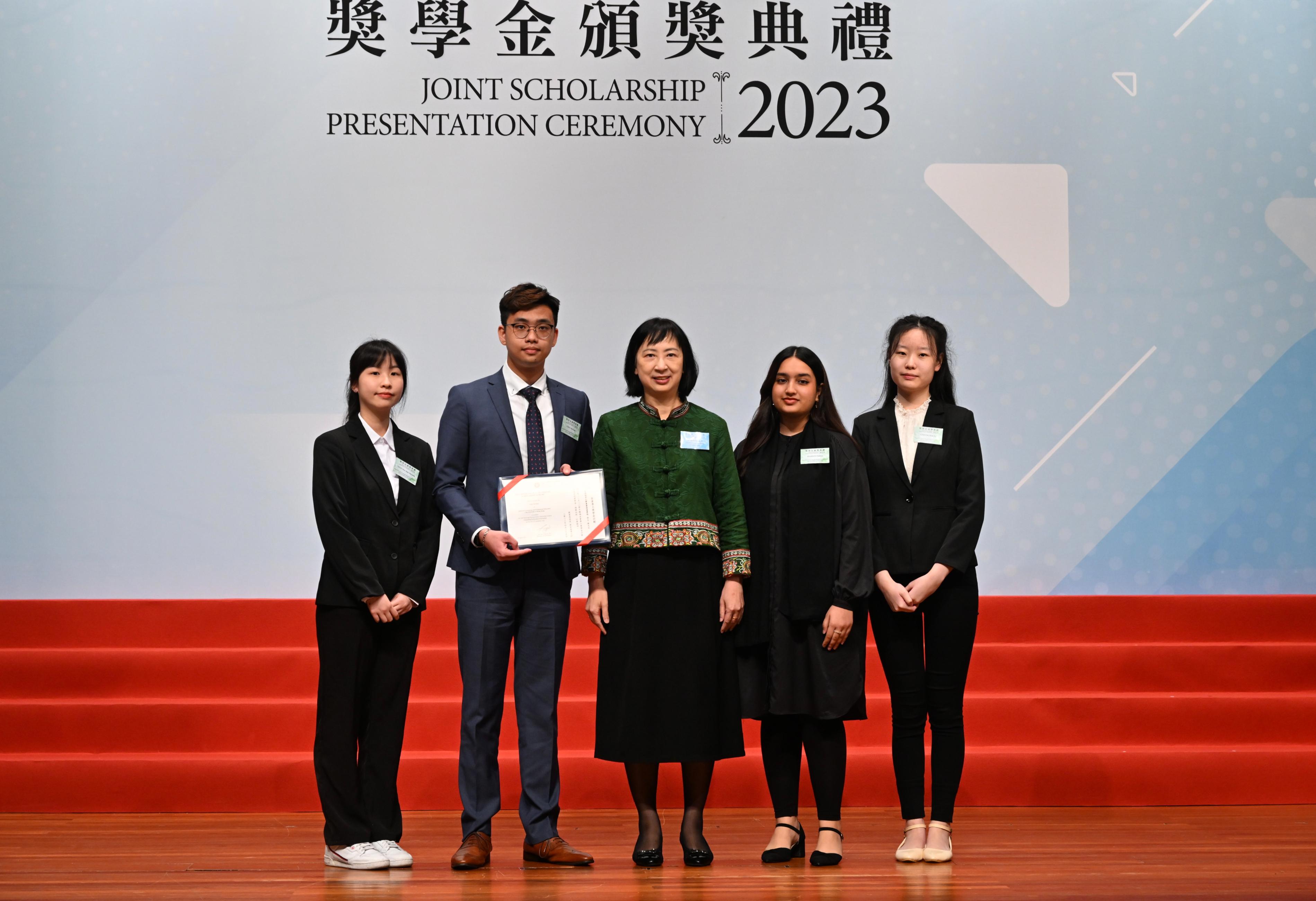 The Education Bureau held the HKSAR Government Scholarship Fund and Self-financing Post-secondary Education Fund Joint Scholarship Presentation Ceremony today (April 25). Photo shows the Permanent Secretary for Education, Ms Michelle Li (centre), presenting a certificate to students who are awarded scholarships under the Self-financing Post-secondary Education Fund.
