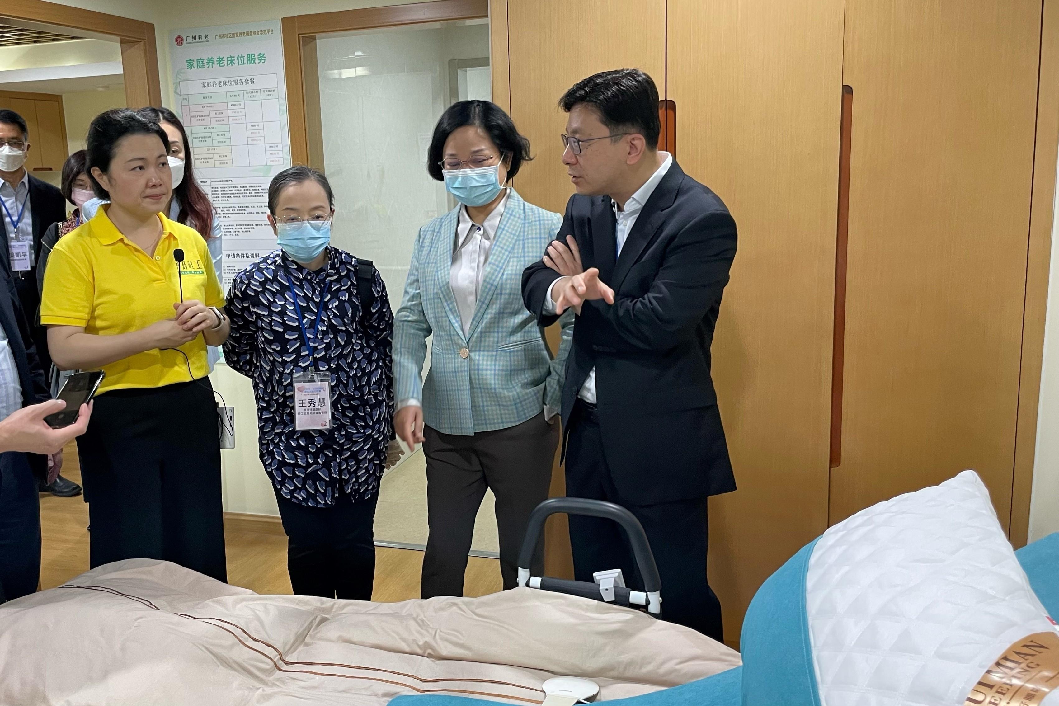 The Secretary for Labour and Welfare, Mr Chris Sun, led the Hong Kong social welfare sector delegation on a visit to Guangdong and visited a model ageing-in-place integrated service centre in Guangzhou yesterday morning (April 25). Photo shows Mr Sun (first right), accompanied by the Commissioner for Rehabilitation of the Labour and Welfare Bureau, Miss Vega Wong (third right), learning more about how electric assistive support on the bed enables elderly persons to better age in place.