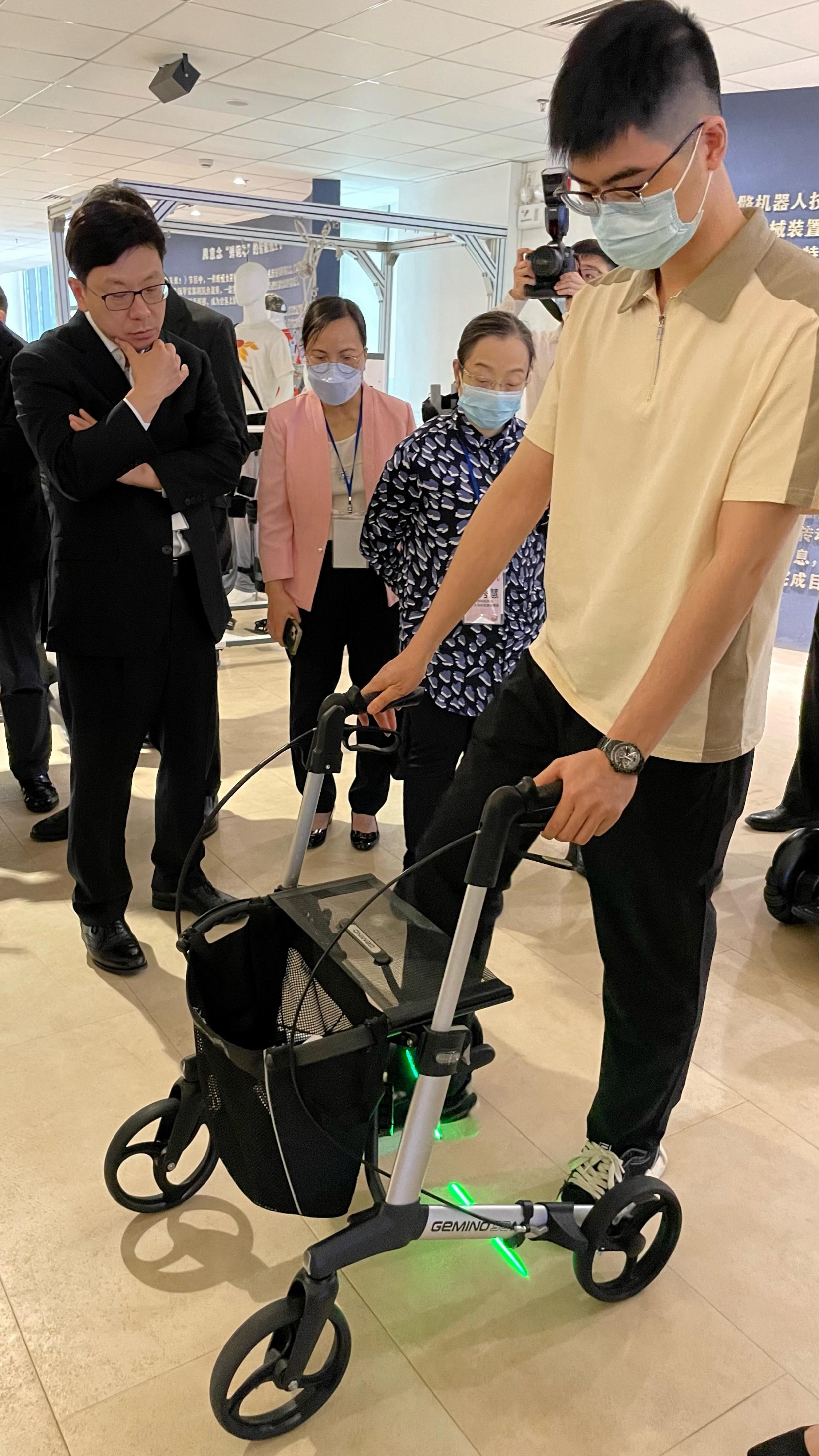 The Secretary for Labour and Welfare, Mr Chris Sun, led the Hong Kong social welfare sector delegation on a visit to Guangdong and visited the Guangdong Provincial Cultural Sports and Rehabilitation Assistive Devices Center for People with Disabilities yesterday morning (April 25). Photo shows Mr Sun (back row, left) observing how a rollator works.