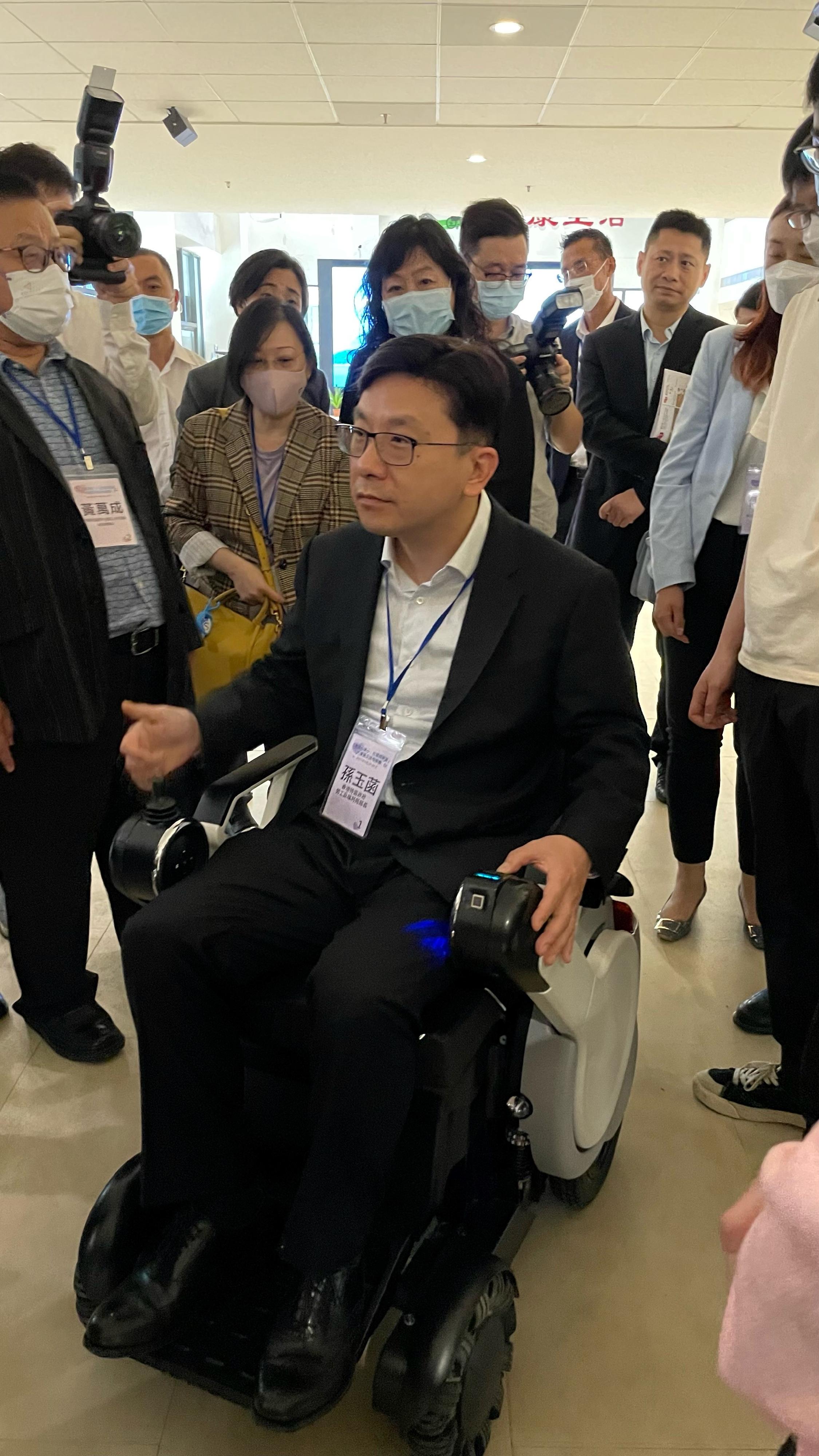 The Secretary for Labour and Welfare, Mr Chris Sun, led the Hong Kong social welfare sector delegation on a visit to Guangdong and visited the Guangdong Provincial Cultural Sports and Rehabilitation Assistive Devices Center for People with Disabilities yesterday morning (April 25). Photo shows Mr Sun (front) on a power wheelchair.