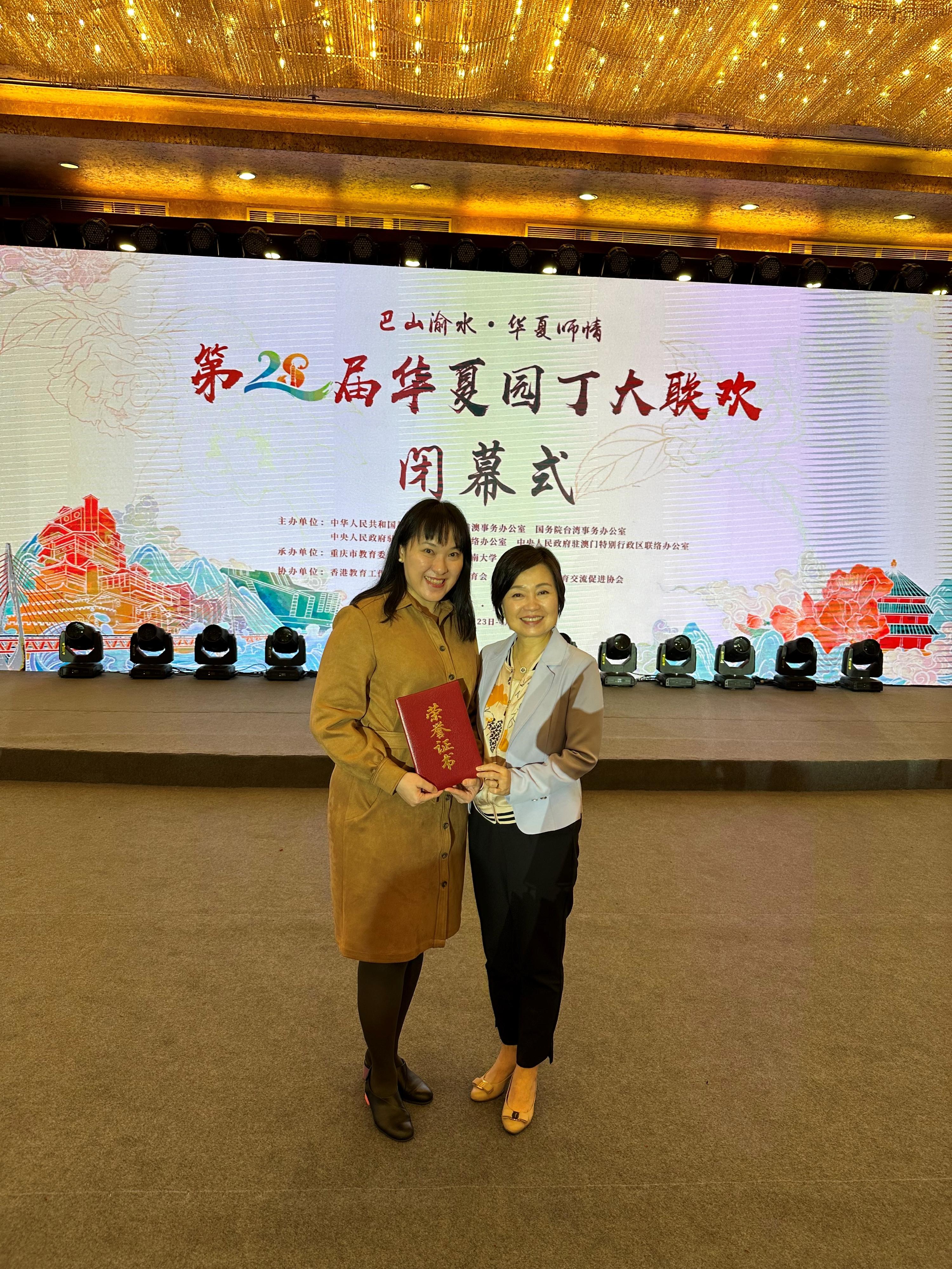 The Secretary for Education, Dr Choi Yuk-lin (right), congratulates the Principal of the Hong Kong Council of the Church of Christ in China Ming Kei College, Ms Cheung Pui-shan (left), on receiving the outstanding paper award of the Gala for Gardeners of the Chinese Nation in Chongqing today (April 27).