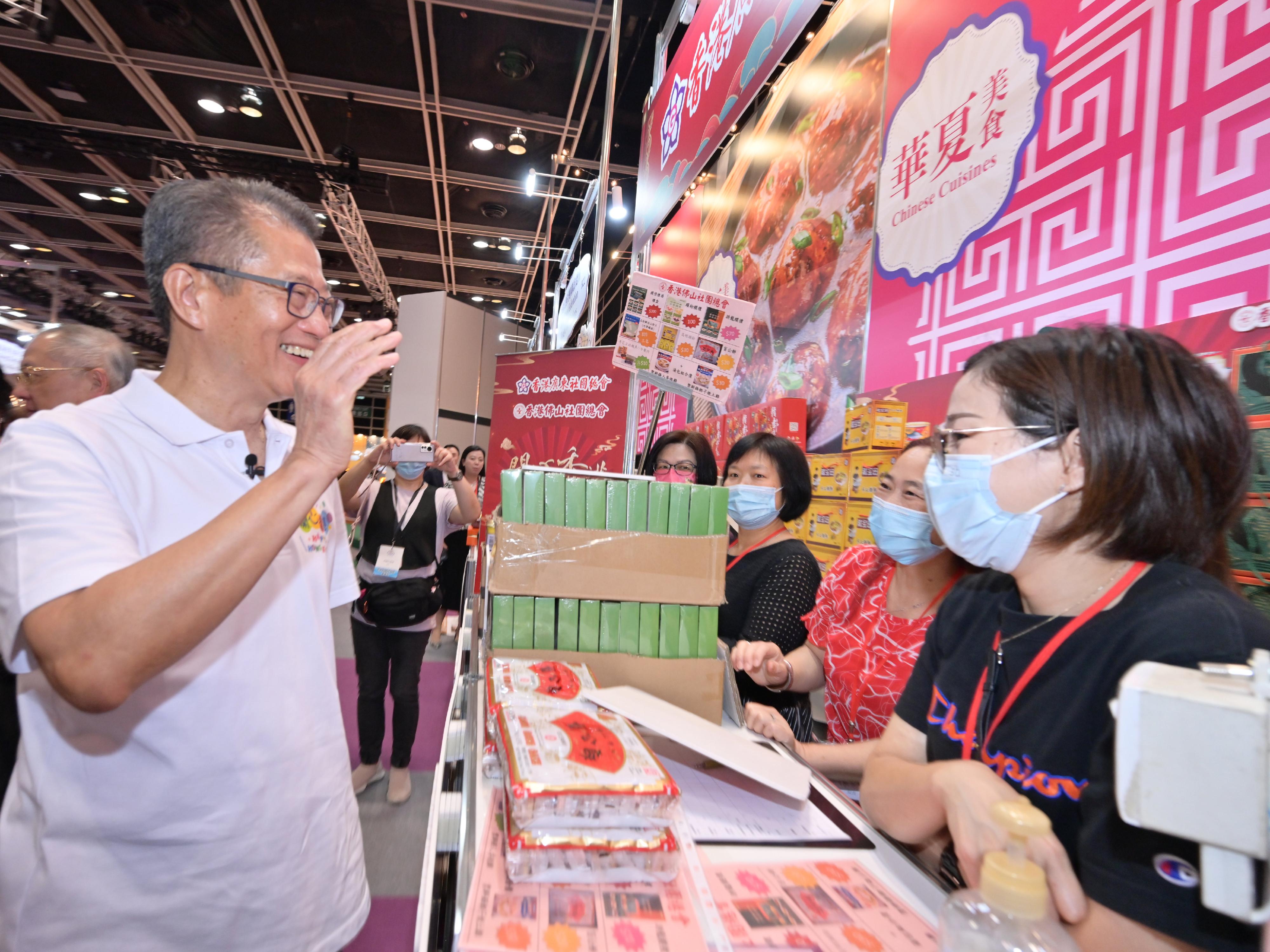 財政司司長陳茂波今日（四月二十九日）主持首場「開心香港」美食巿集開幕典禮。圖示陳茂波（左）參觀展覽攤位。