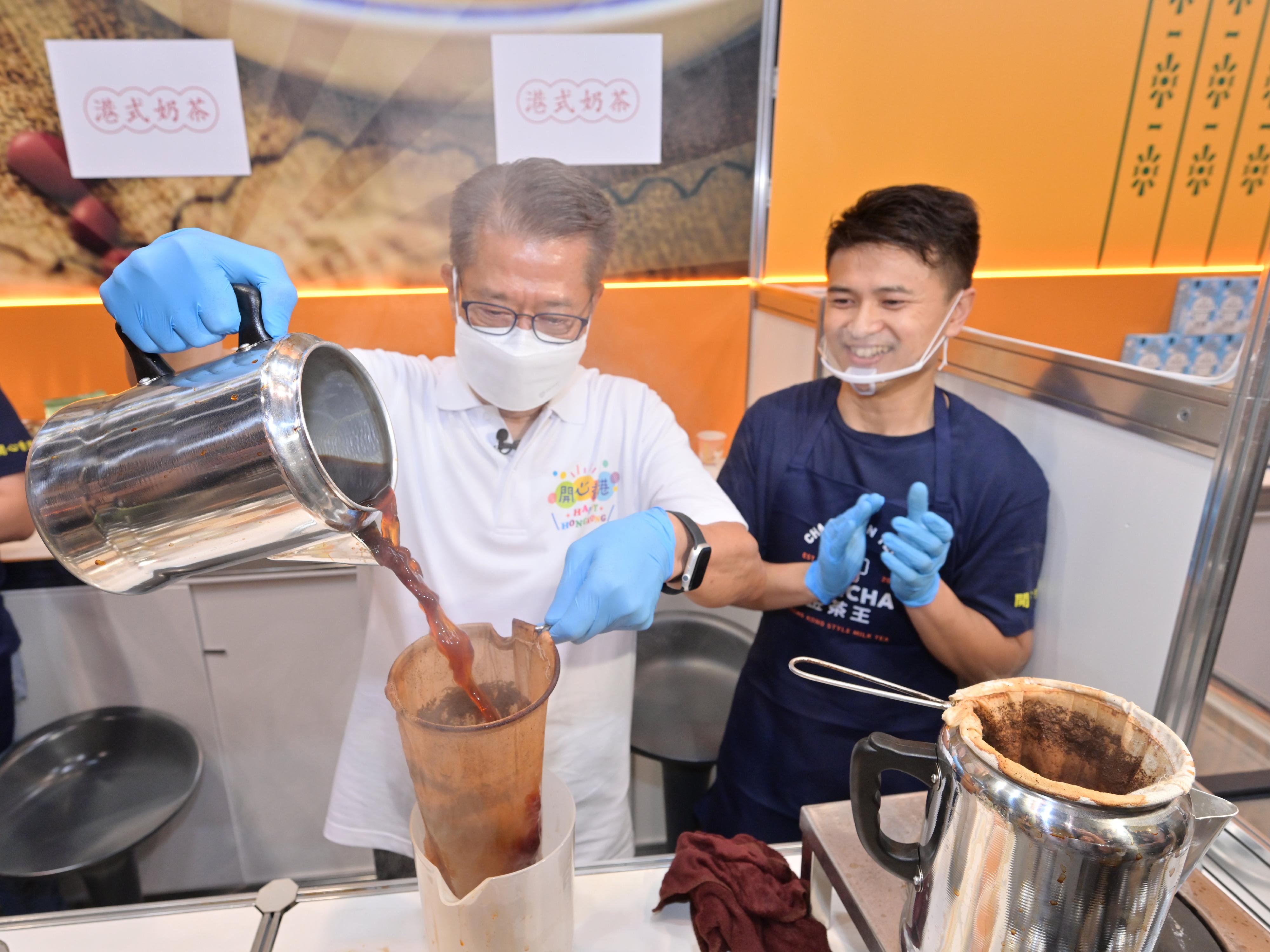 財政司司長陳茂波今日（四月二十九日）主持首場「開心香港」美食巿集開幕典禮。圖示陳茂波（左）與參展商一起製作奶茶。


