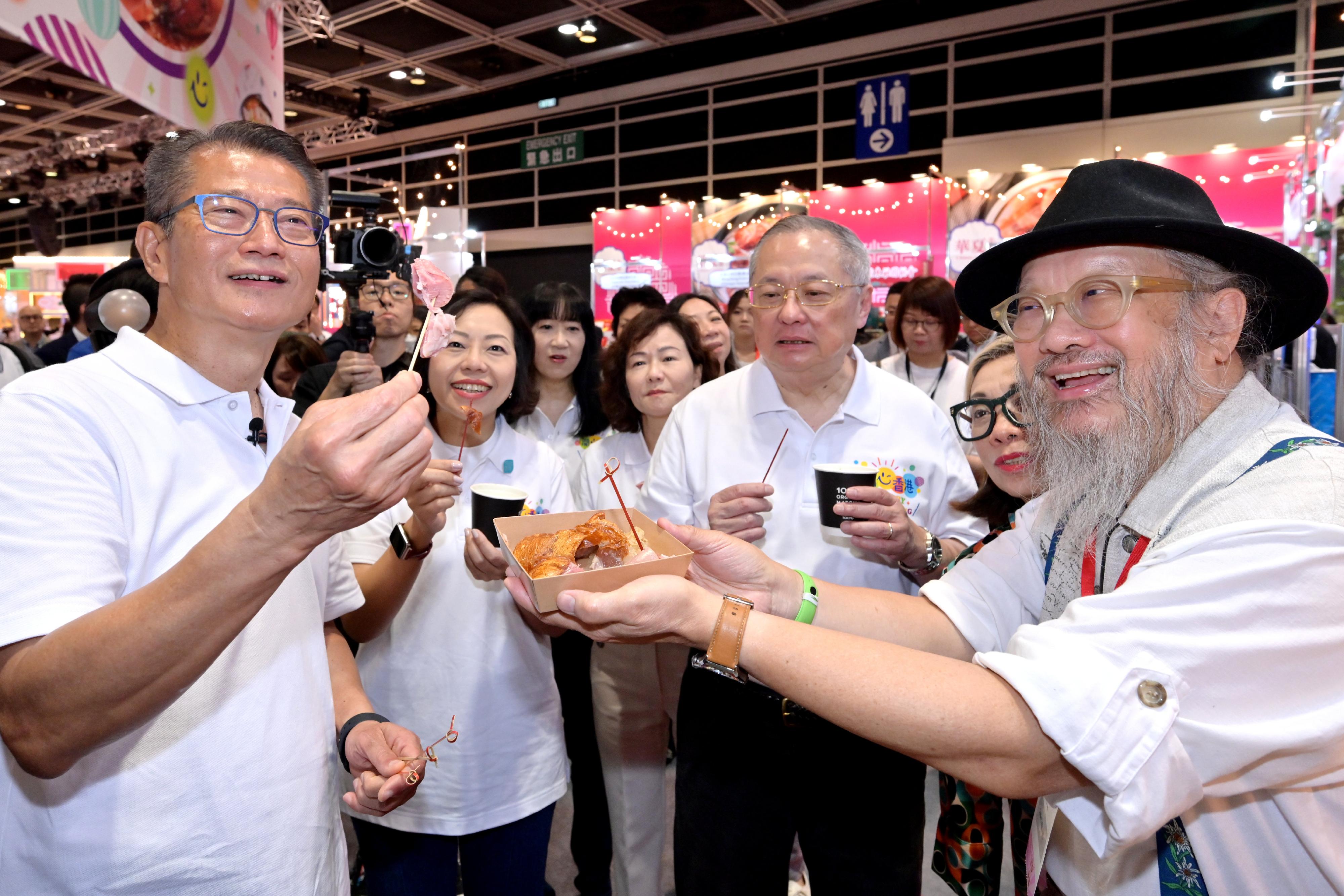 The Financial Secretary, Mr Paul Chan, officiated at the opening ceremony of the first "Happy Hong Kong" Gourmet Marketplace today (April 29). Photo shows Mr Chan (first left), accompanied by Non-official Member of the Executive Council, Legislative Council Member (Catering), Mr Tommy Cheung (second right); and the Secretary for Home and Youth Affairs, Miss Alice Mak (second left), tasting food at the Gourmet Marketplace.