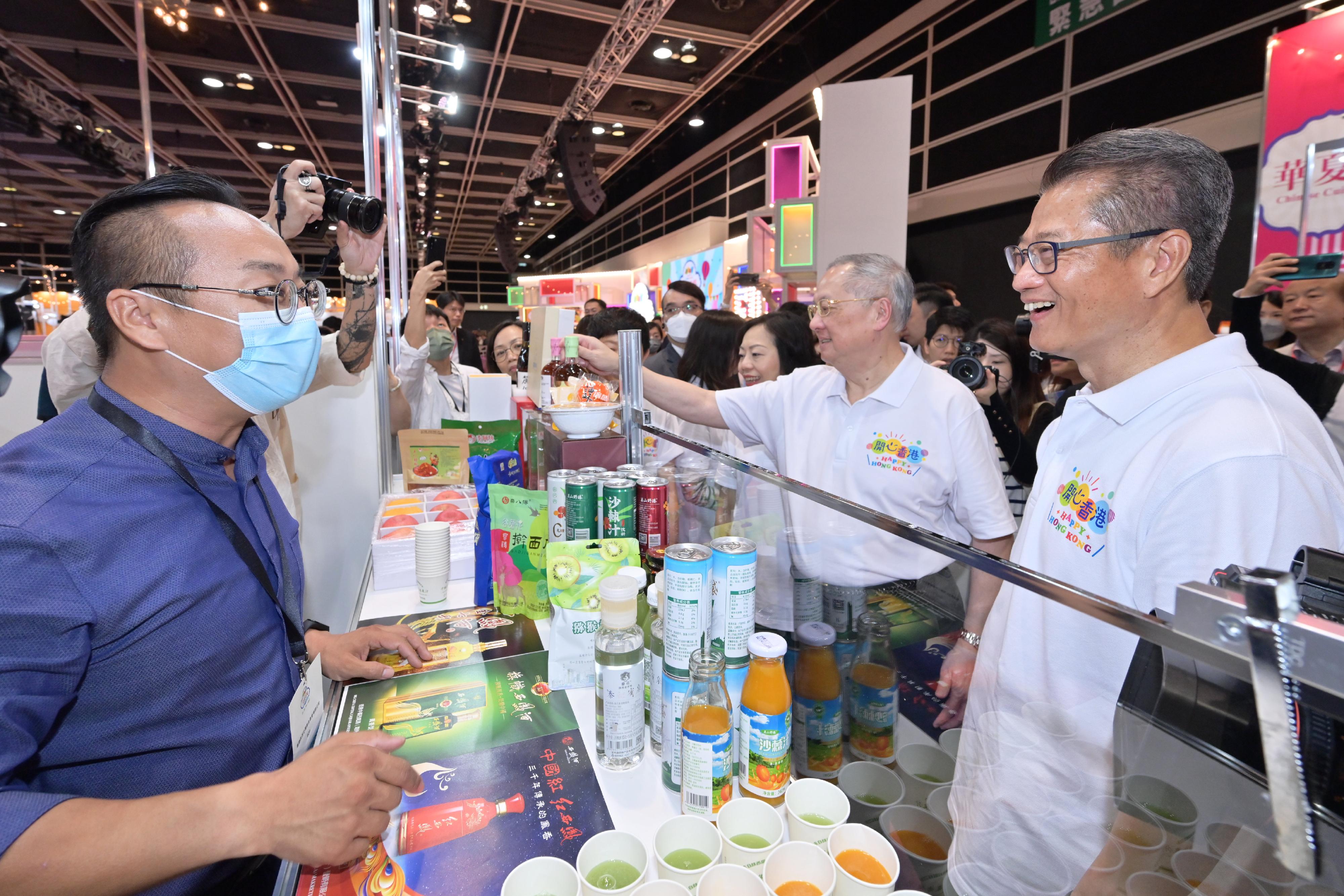 The Financial Secretary, Mr Paul Chan, officiated at the opening ceremony of the first "Happy Hong Kong" Gourmet Marketplace today (April 29). Photo shows Mr Chan (first right), accompanied by Non-official Member of the Executive Council, Legislative Council Member (Catering), Mr Tommy Cheung (second right); and the Secretary for Home and Youth Affairs, Miss Alice Mak (third right), exchanging views with exhibitor.
