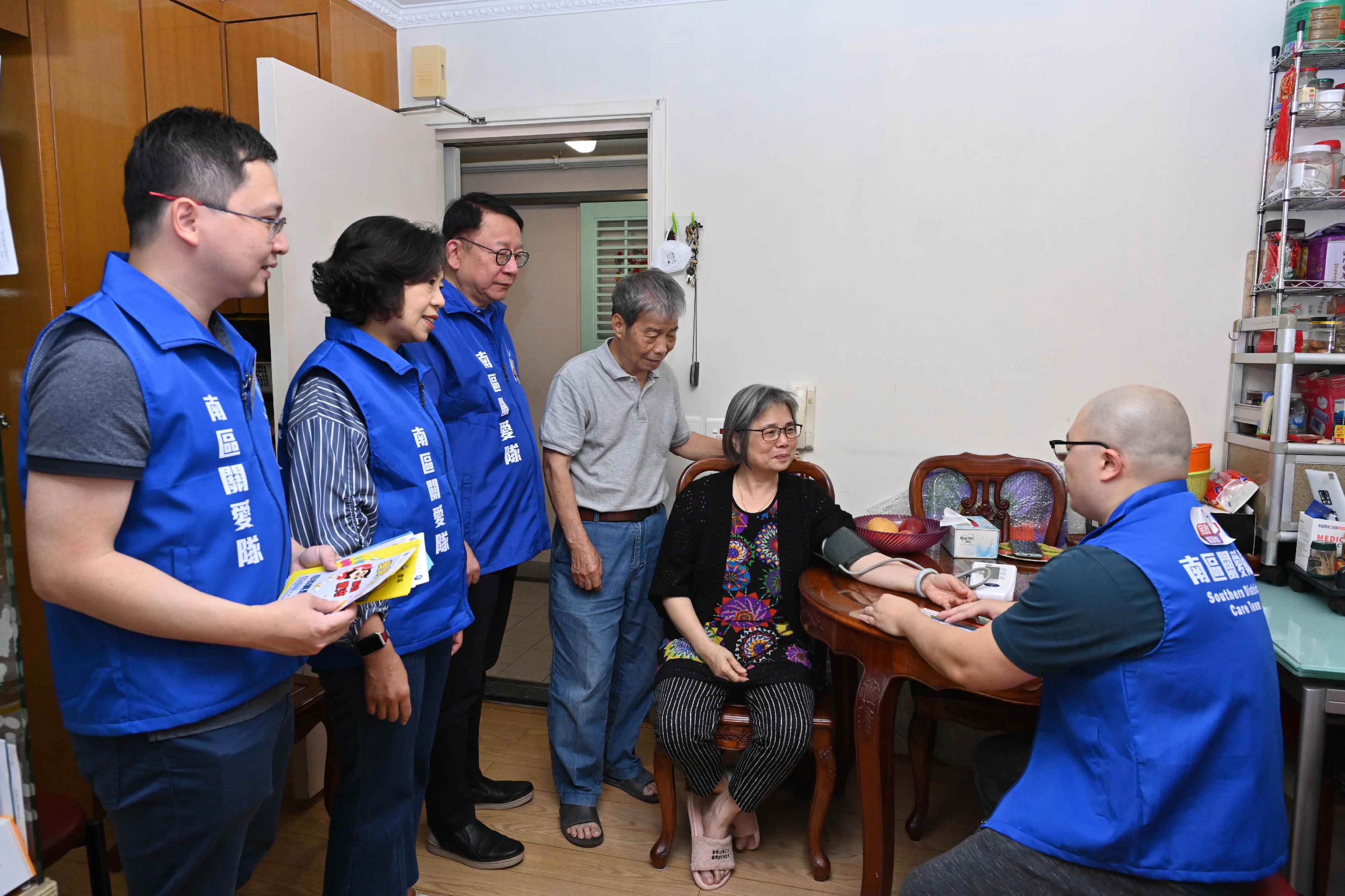 The Chief Secretary for Administration, Mr Chan Kwok-ki, attended the pledging ceremony of Care Teams in Southern District today (April 30). Photo shows Mr Chan (third left), accompanied by the Secretary for Home and Youth Affairs, Miss Alice Mak (second left), visiting an elderly doubleton living in Southern District before the ceremony and assisting them to check their blood pressure.
