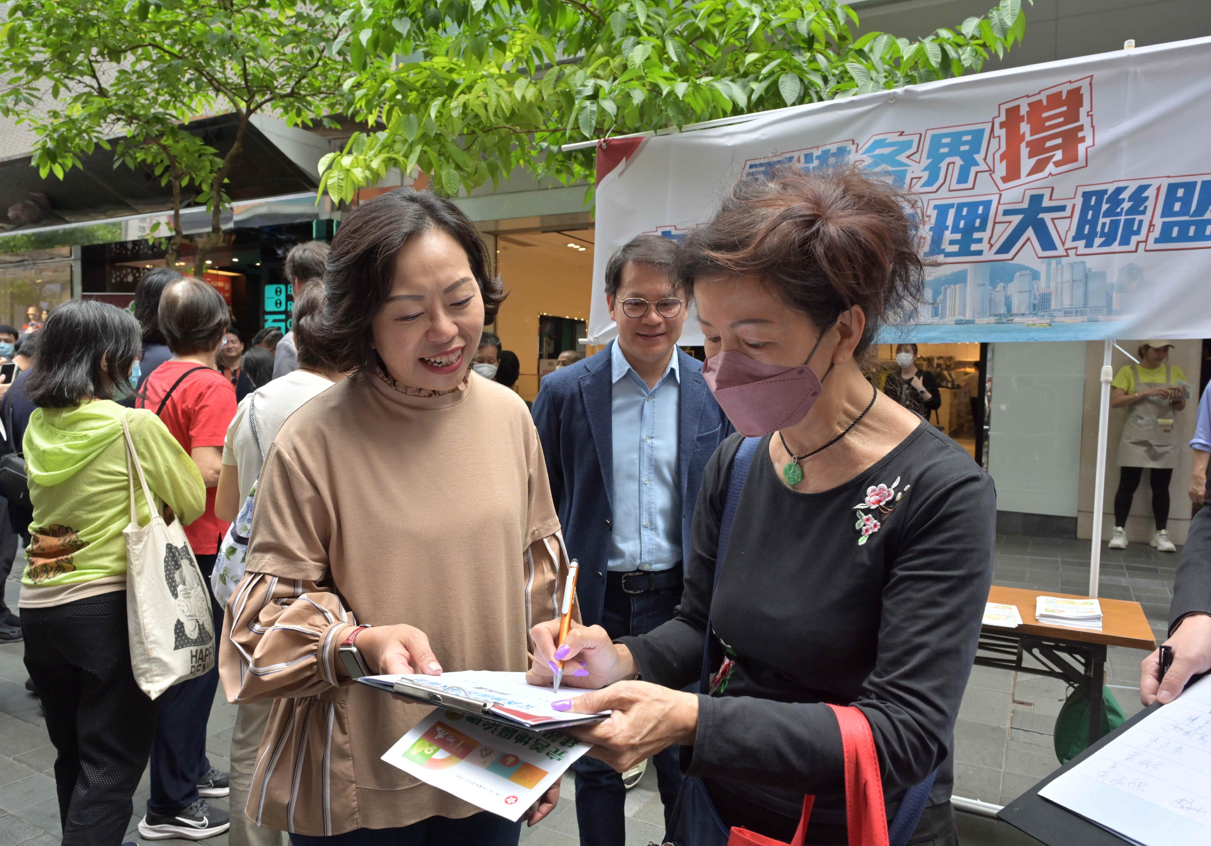 民政及青年事務局局長麥美娟今日（五月五日）出席香港各界撐完善地區治理大聯盟成立儀式暨啟動禮。圖示麥美娟（左）向市民宣傳完善地區治理建議方案。