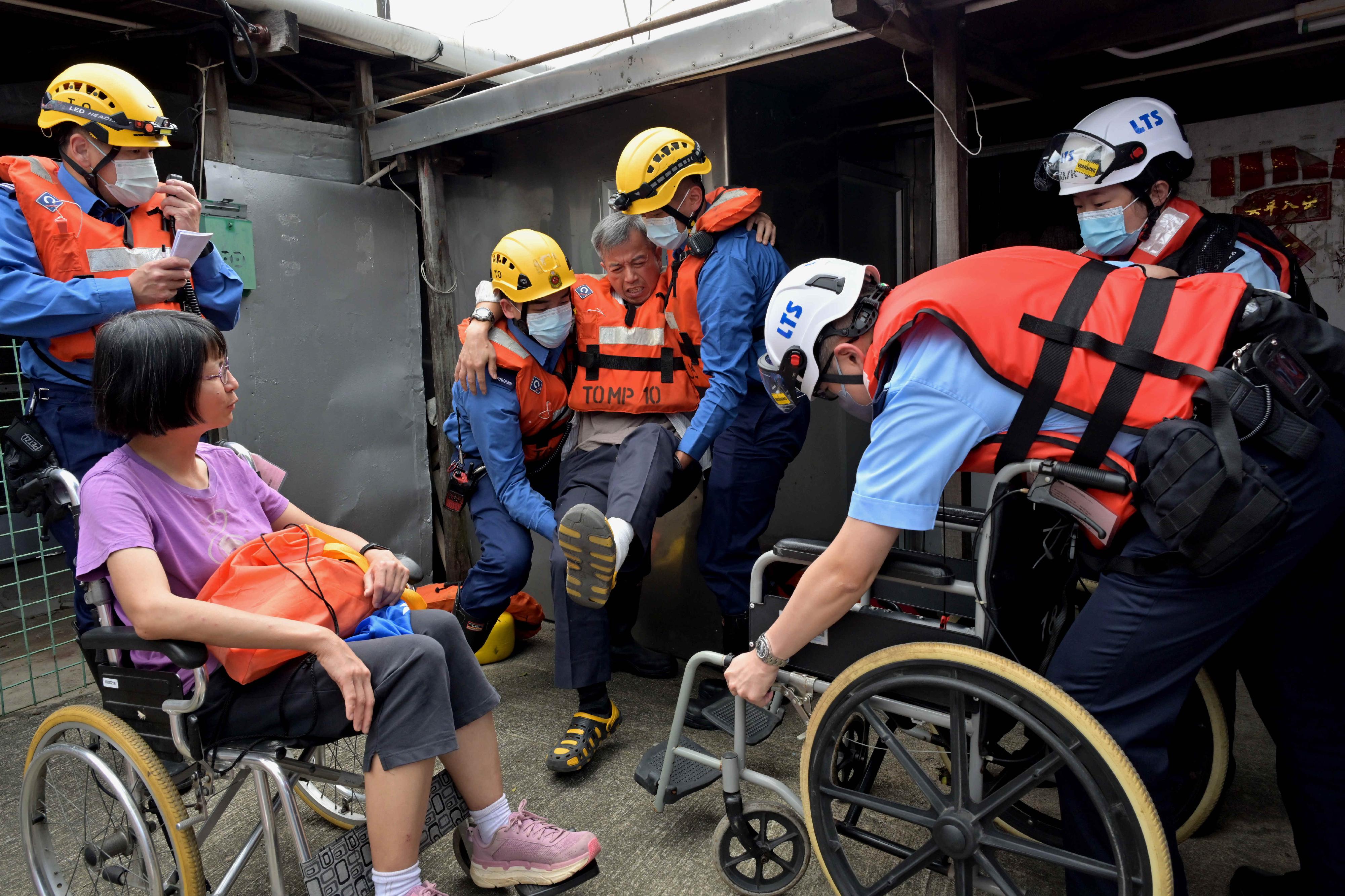離島民政事務處今日（五月十日）在大澳舉行跨部門水浸模擬救援及疏散演練。圖示居民模擬被困及致電求助後，警務處派員拯救。