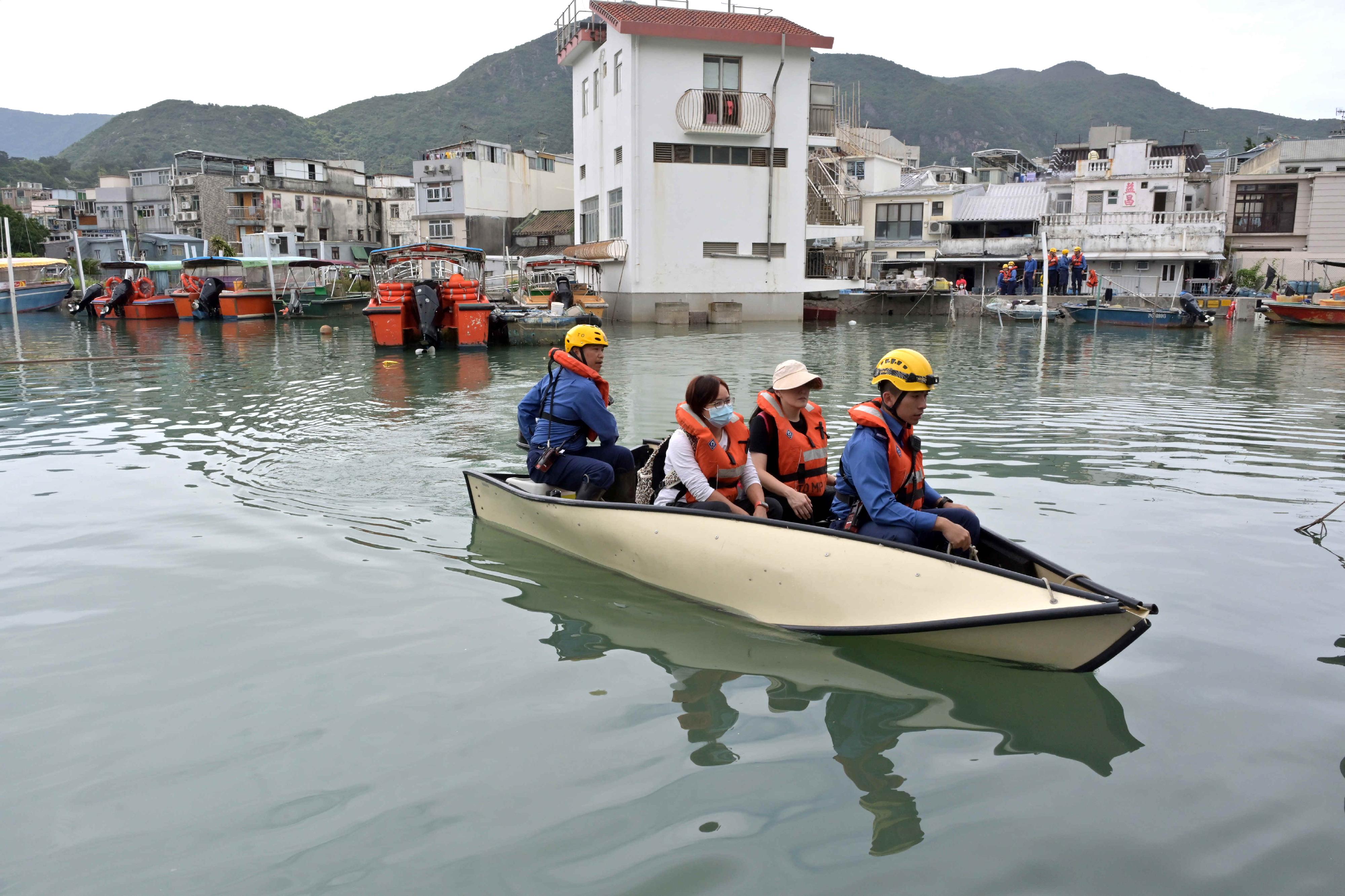 The Islands District Office conducted an inter-departmental rescue and evacuation drill in the event of flooding in Tai O today (May 10). Photo shows firemen rescuing trapped residents during the drill.
