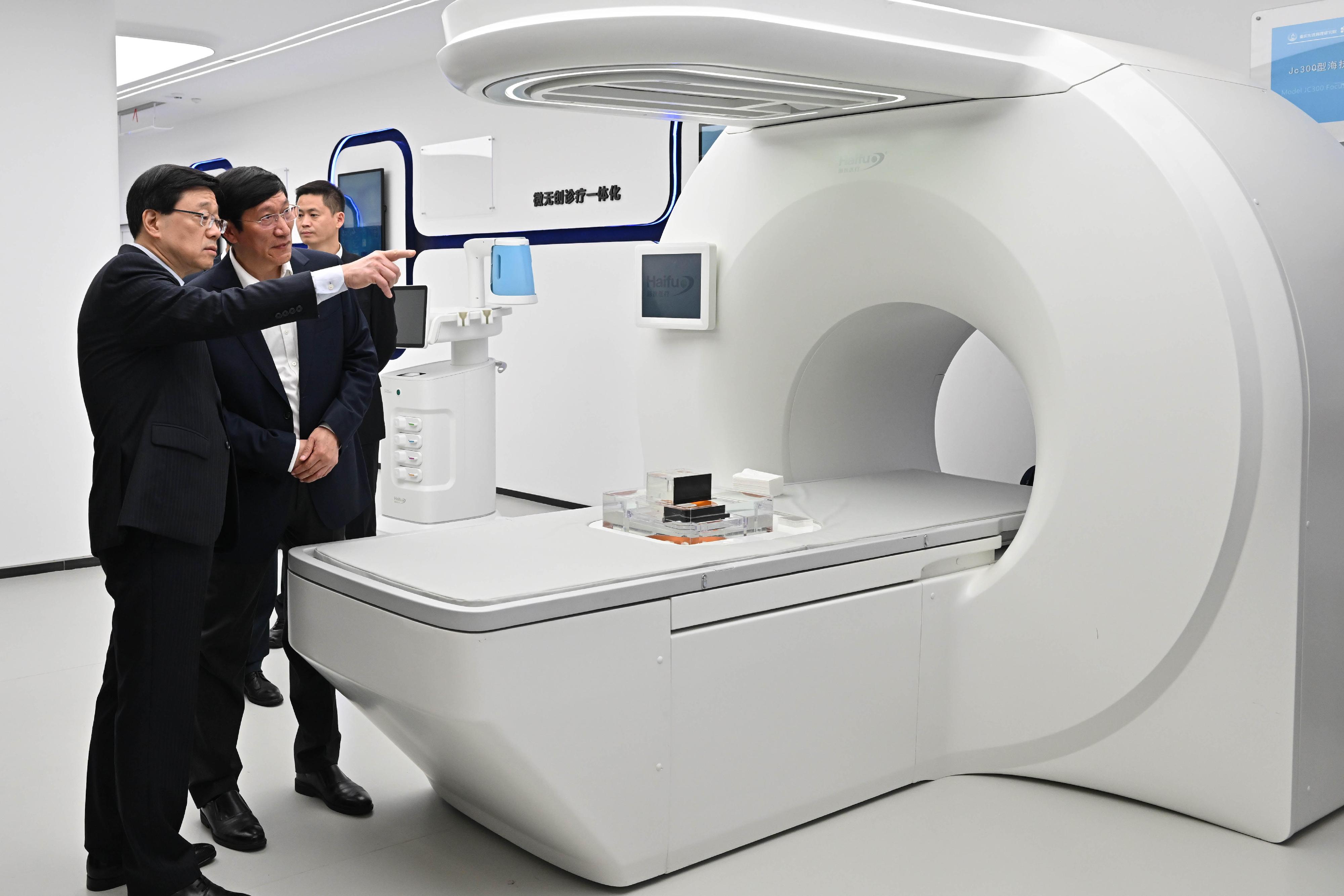 行政長官李家超（左一）今日（五月十一日）到訪重慶金鳳實驗室，了解超聲波治療儀的應用。