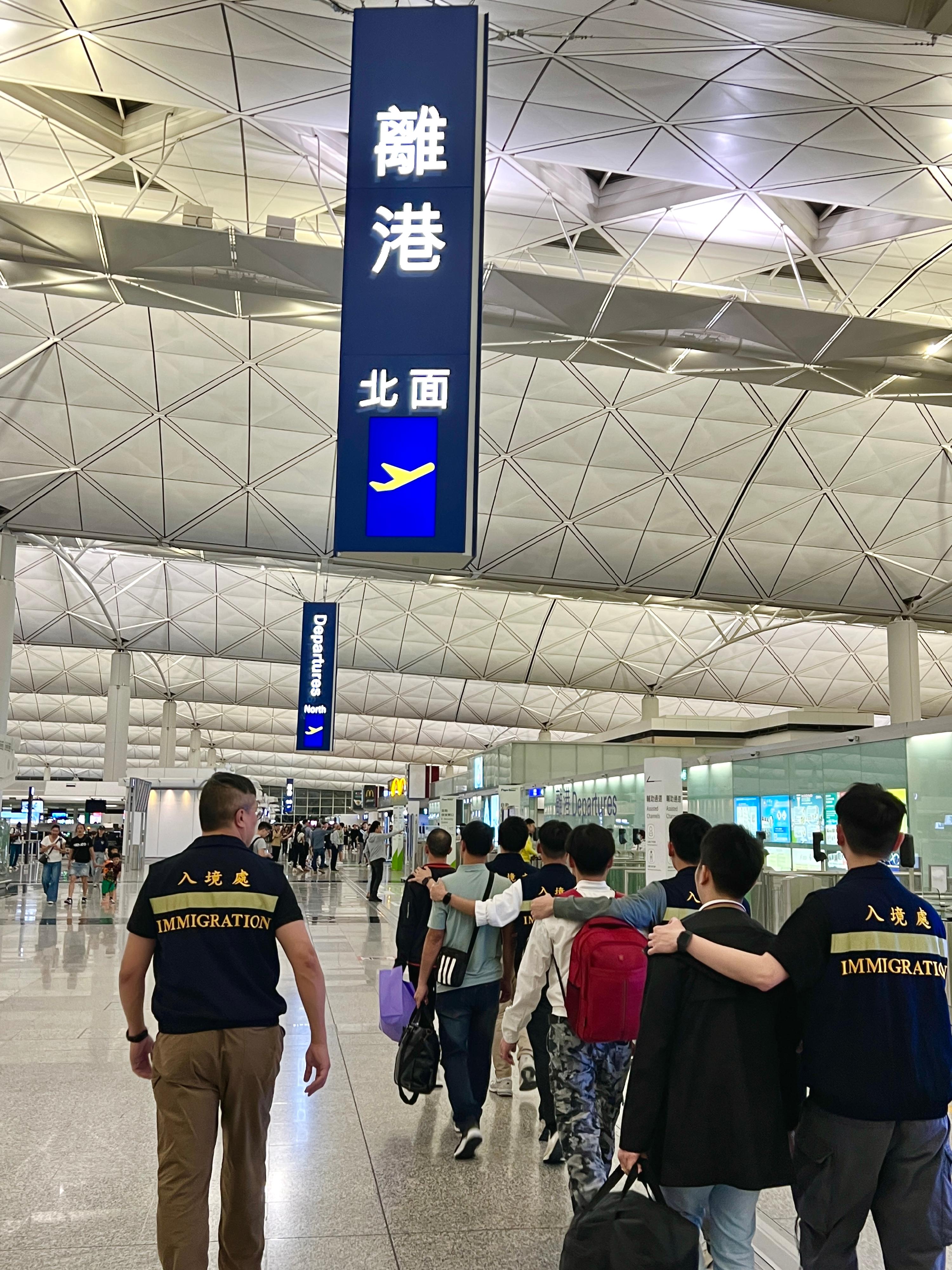 The Immigration Department (ImmD) carried out repatriation operation yesterday (May 12). A total of 23 Vietnamese illegal immigrants were repatriated to Vietnam. Photo shows removees being escorted by ImmD officers to depart Hong Kong.