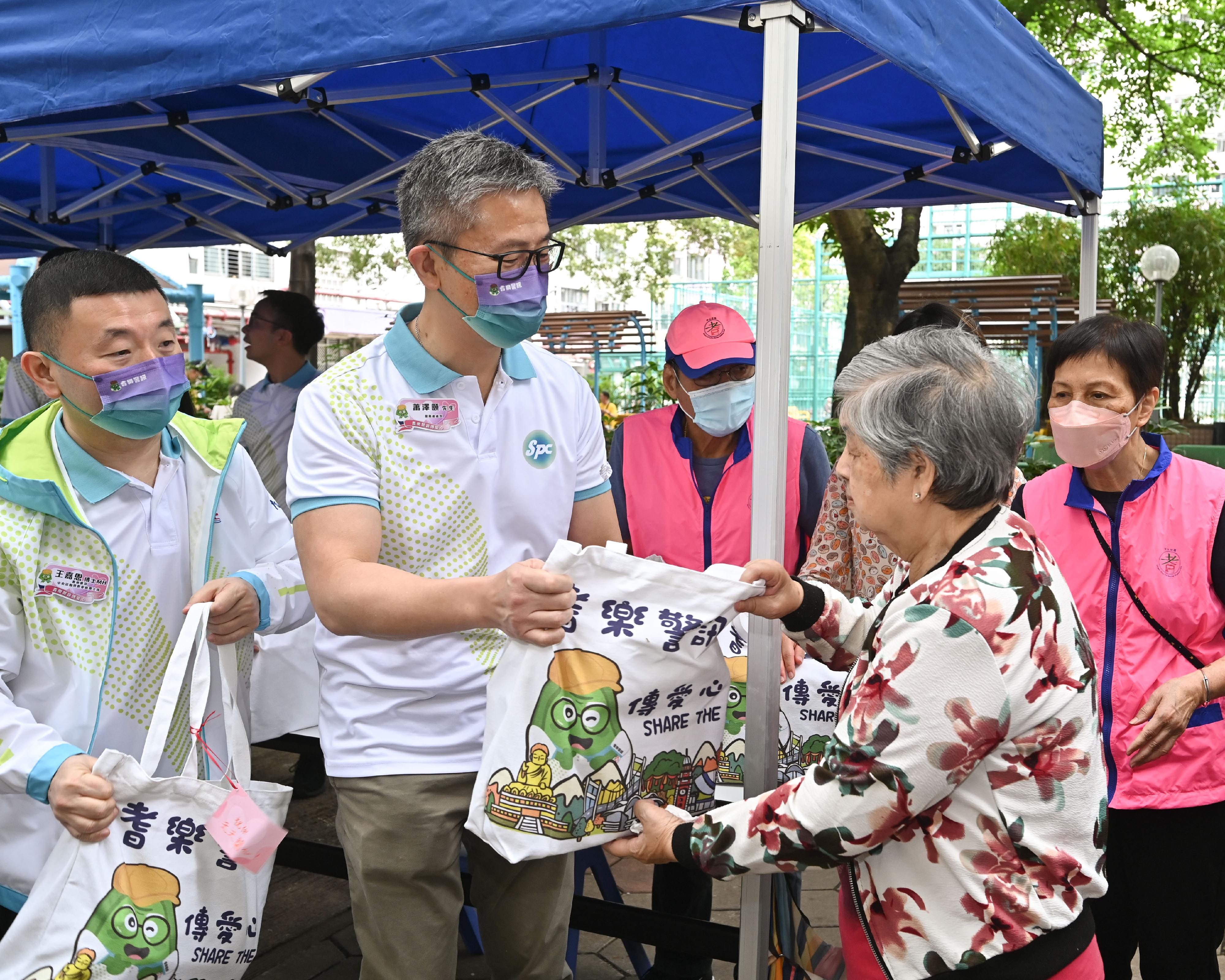 耆乐警讯于今日（五月十三日）开展「耆乐警讯传爱心」活动。图示警务处处长萧泽颐（左二）向长者派发福袋。