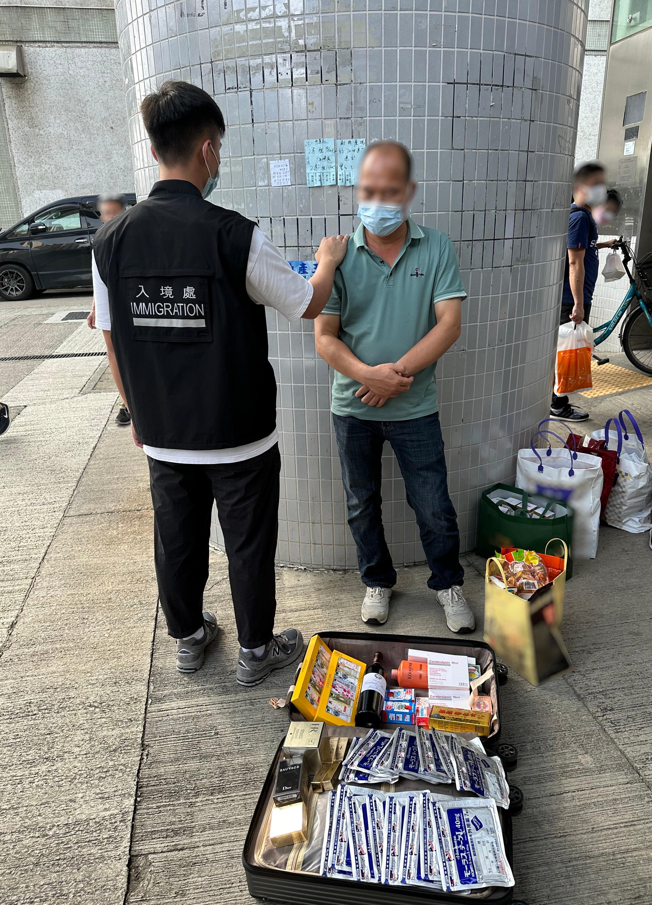 The Immigration Department mounted a series of territory-wide anti-illegal worker operations codenamed "Lightshadow", "Twilight" and a joint operation with the Hong Kong Police Force codenamed "Windsand" for four consecutive days from May 15 to yesterday (May 18). Photo shows a Mainland visitor involved in suspected parallel trading activities and his goods.