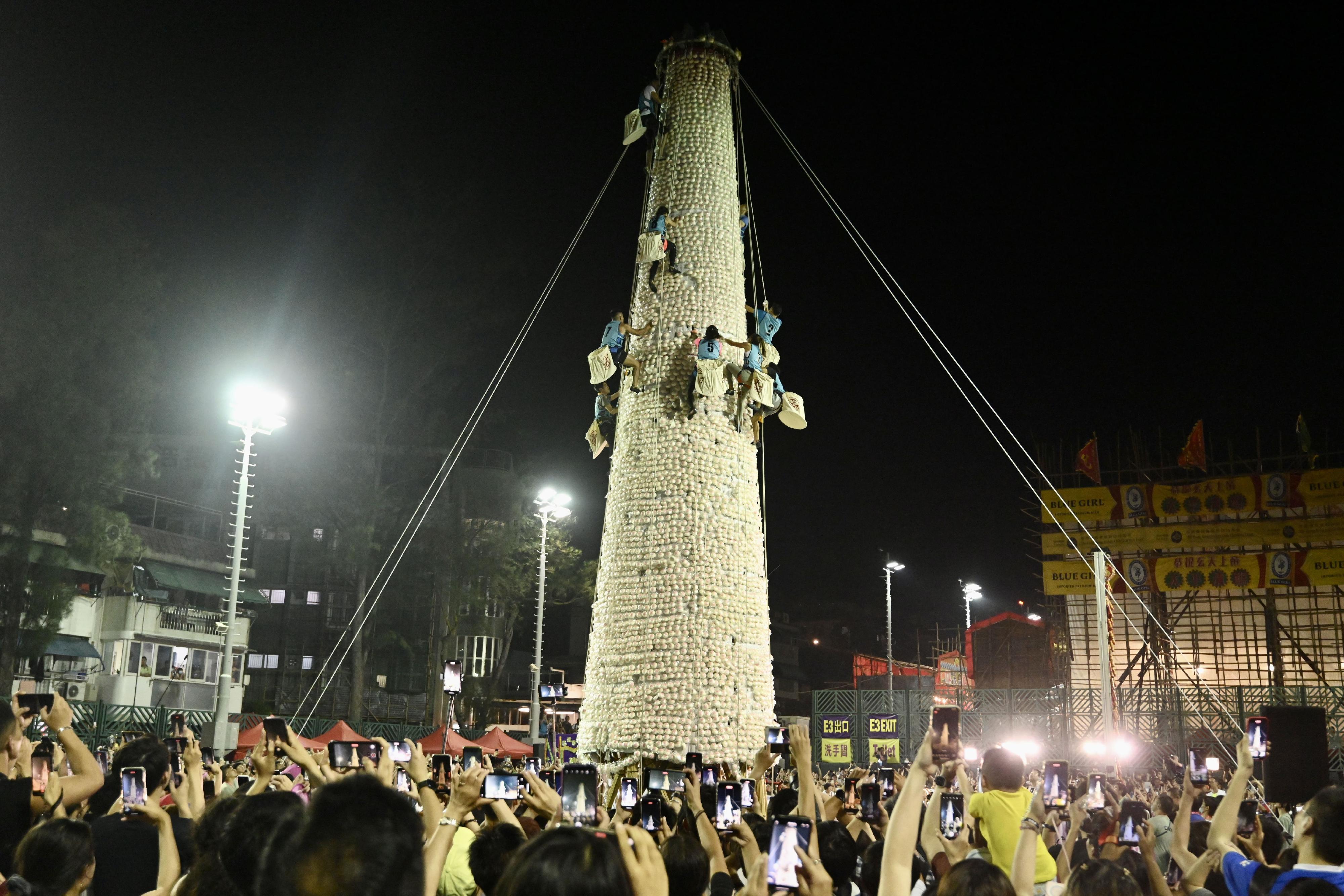 The Bun Scrambling Competition on Cheung Chau concluded early this morning (May 27). Photo shows the finalists scrambling up the bun tower to gather as many buns as they can within a three-minute time limit to vie for the championships.