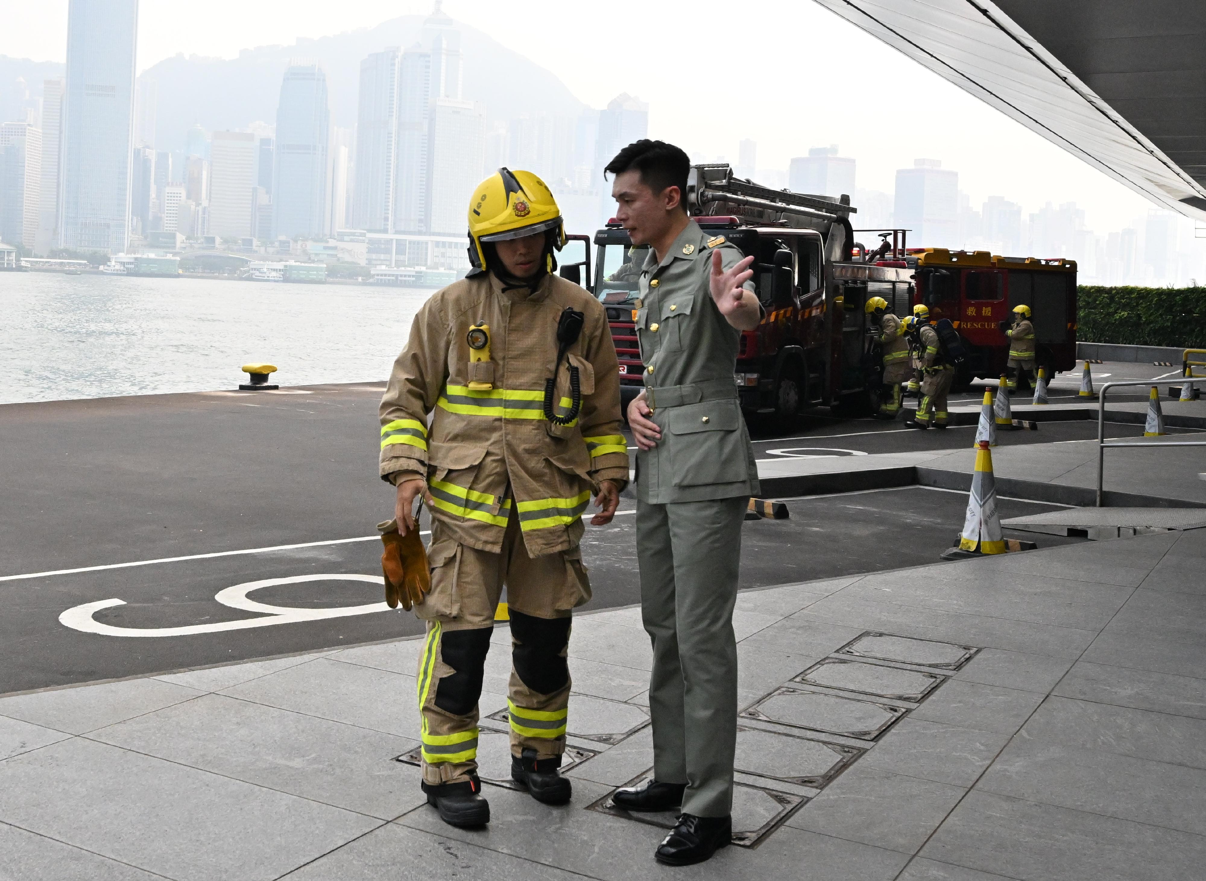香港海關及消防處今日（五月三十日）下午在海運碼頭聯合舉行代號「把關者II」的反恐演習。圖示海關人員向接報到場的消防處人員講述事件經過。
