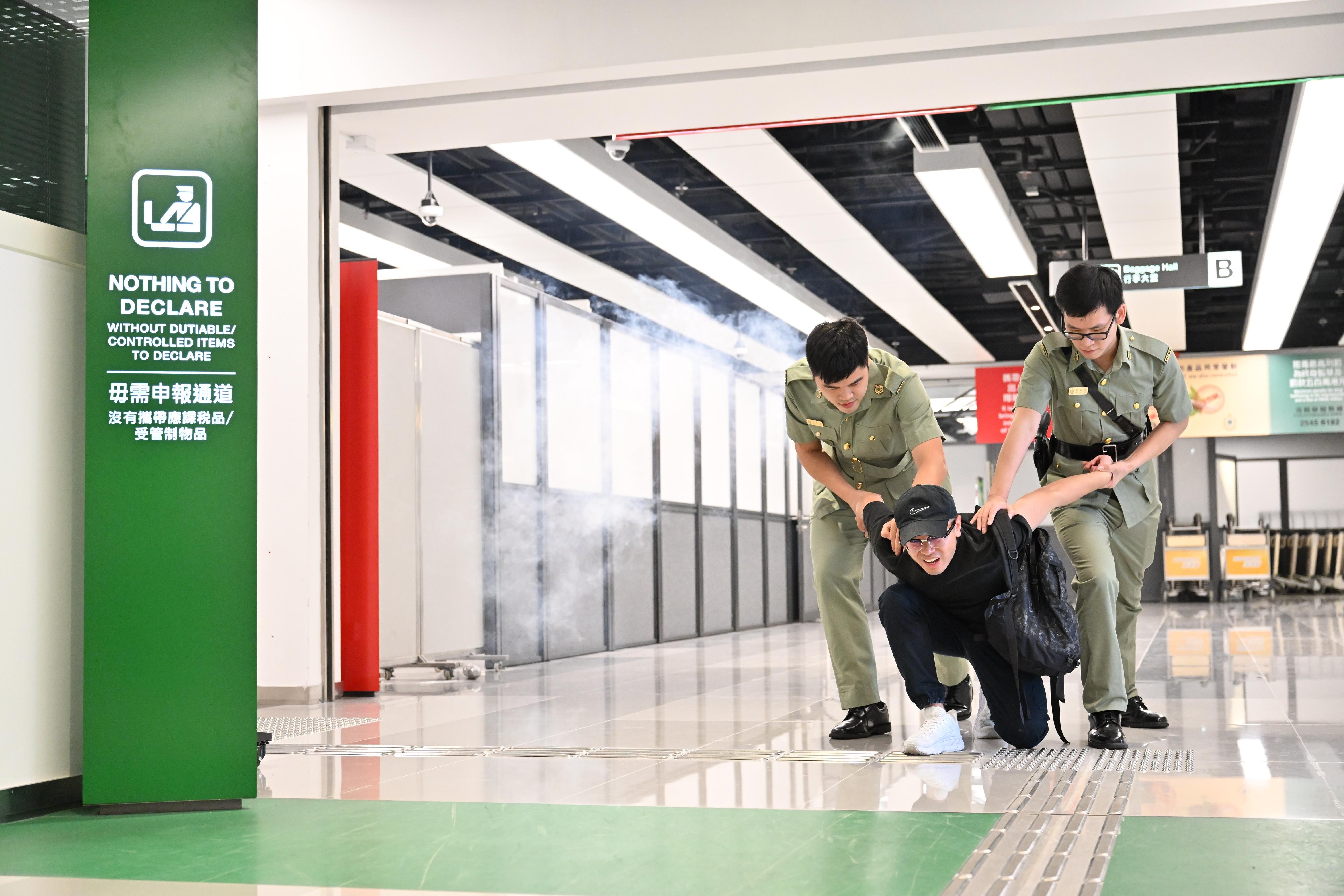 Hong Kong Customs and the Fire Services Department co-organised a counter-terrorism exercise codenamed "GATEKEEPER II" this afternoon (May 30) at the Ocean Terminal. Photo shows Customs officers subduing an attacker.