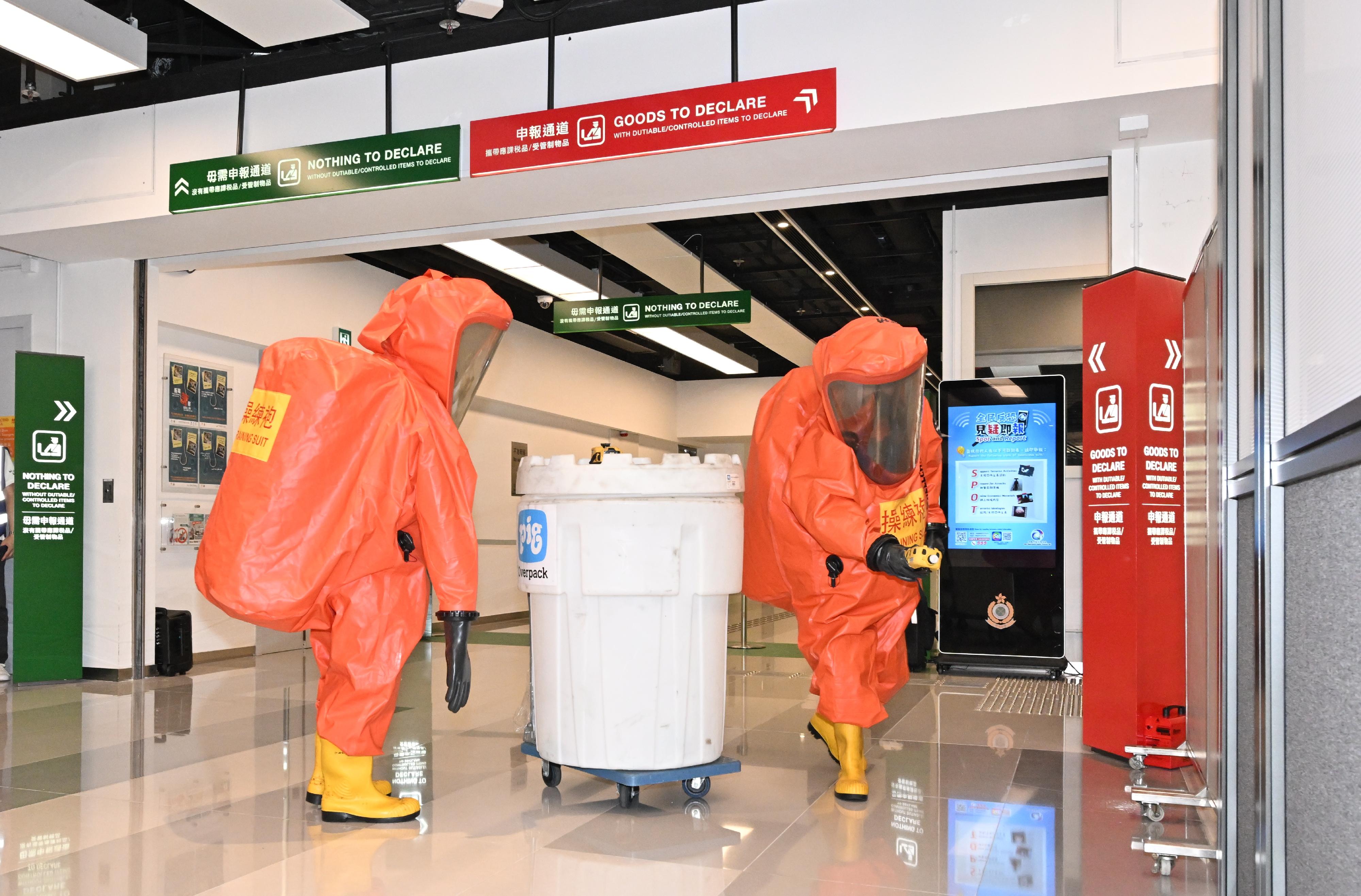 Hong Kong Customs and the Fire Services Department (FSD) co-organised a counter-terrorism exercise codenamed "GATEKEEPER II" this afternoon (May 30) at the Ocean Terminal. Photo shows FSD officers detecting hazardous material with a portable multi-gas detector at the scene.