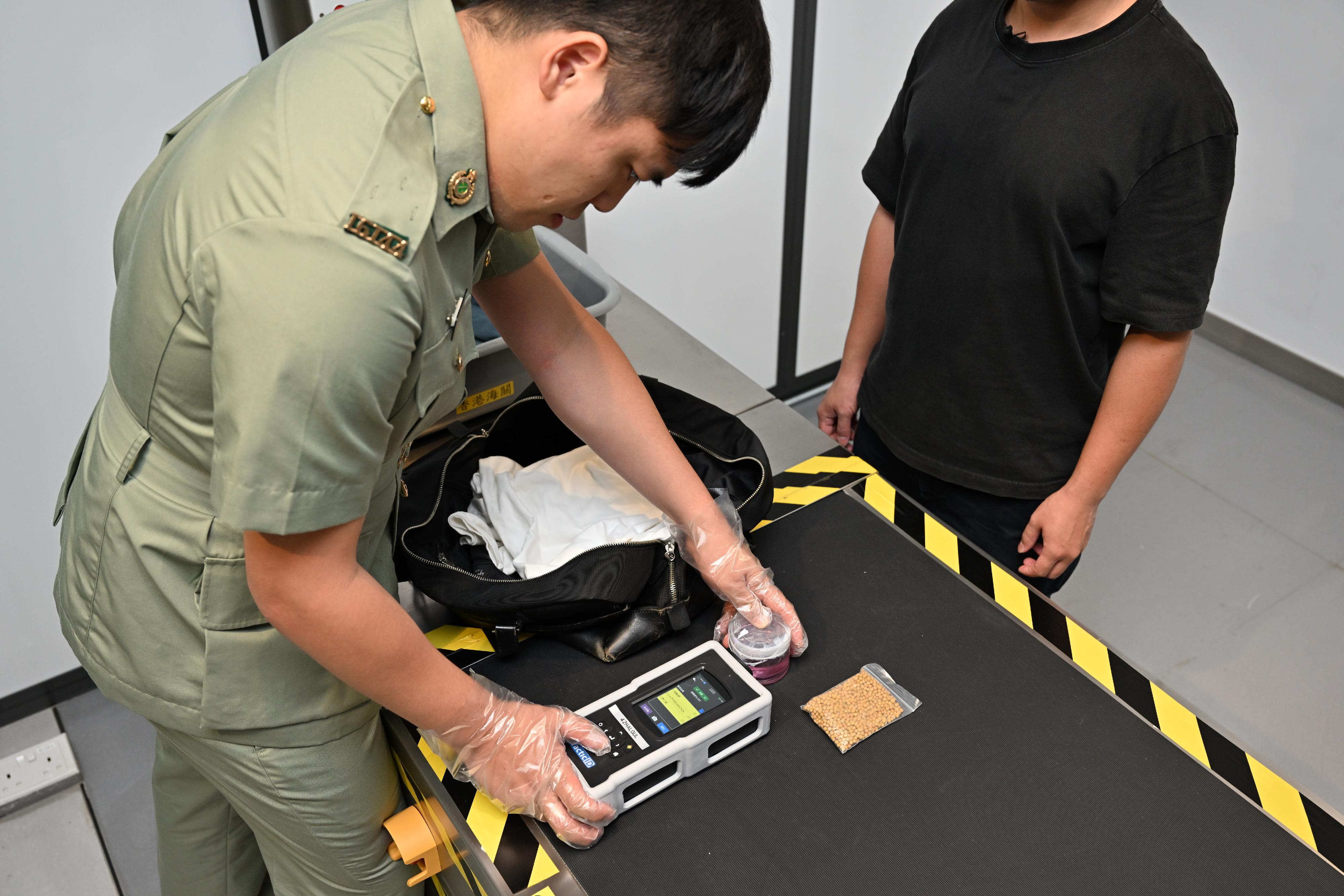 Hong Kong Customs and the Fire Services Department co-organised a counter-terrorism exercise codenamed "GATEKEEPER II" this afternoon (May 30) at the Ocean Terminal. Photo shows a Customs officer conducting Customs clearance with advanced equipment.