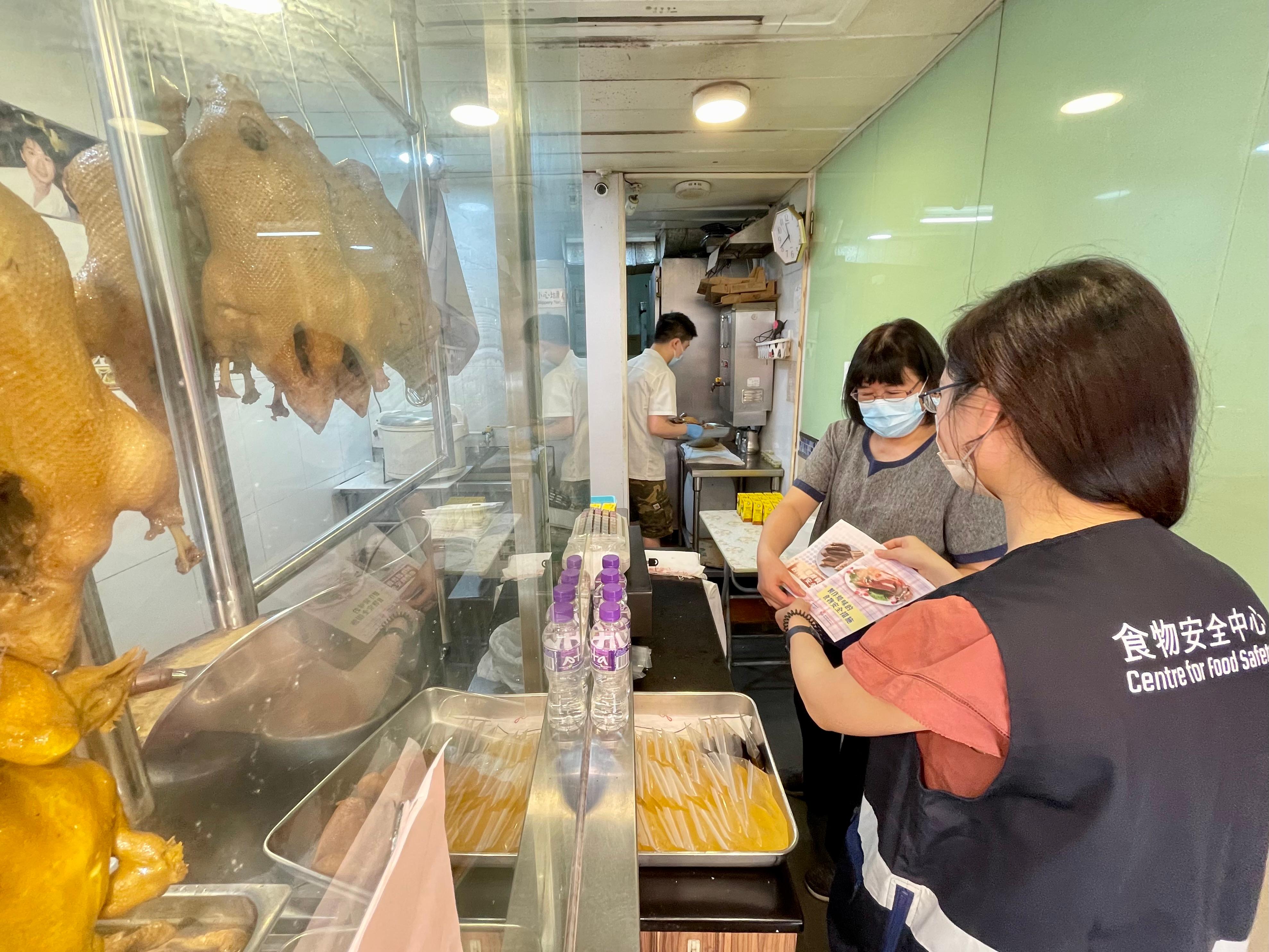 The Centre for Food Safety (CFS) of the Food and Environmental Hygiene Department today (May 30) reminded members of the public and food businesses to pay special attention to food safety during the summer. Photo shows a CFS staff member distributing leaflets on food safety.
