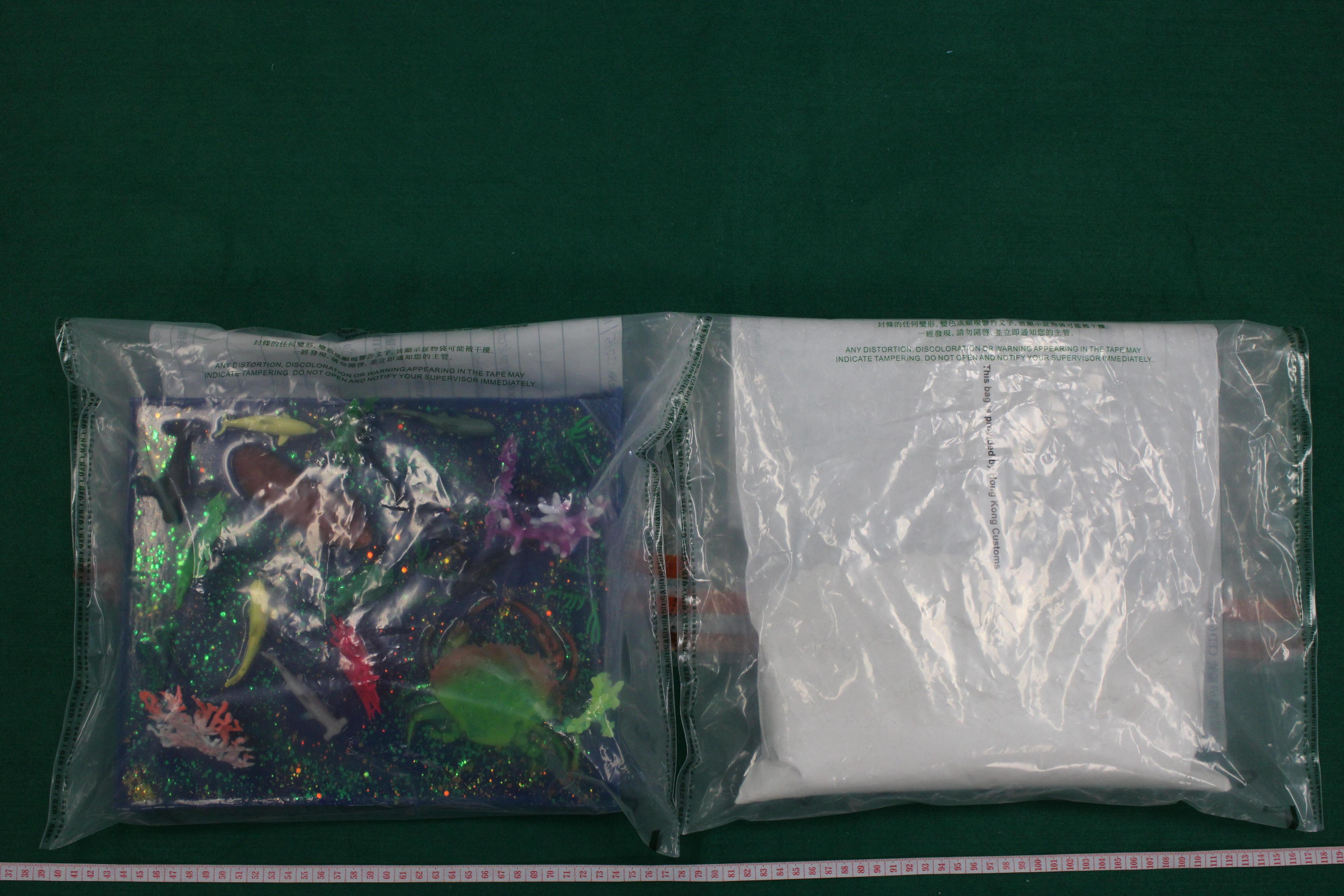 香港海關五月二十九日在香港國際機場檢獲約一公斤懷疑海洛英，估計市值約七十九萬元。圖示檢獲的懷疑海洛英和用作收藏毒品的塑膠擺設。