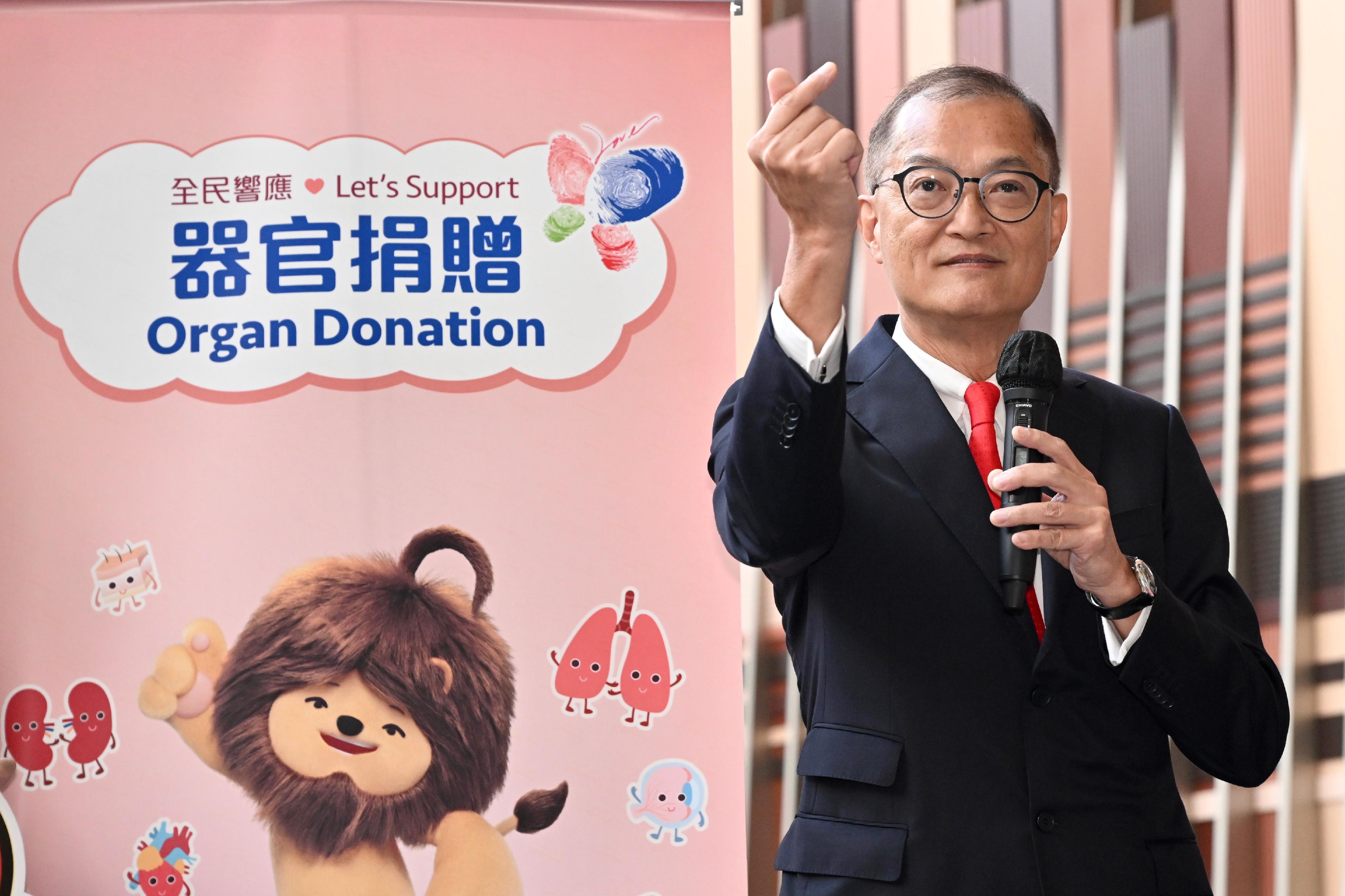 While attending an organ donation promotion event at the Legislative Council Complex today (June 7), the Secretary for Health, Professor Lo Chung-mau, uses a "little heart" hand gesture to remind the public of the successful case in which a 4-month-old baby girl managed to survive upon receiving a heart donation. He called for continued support from the public for organ donations.