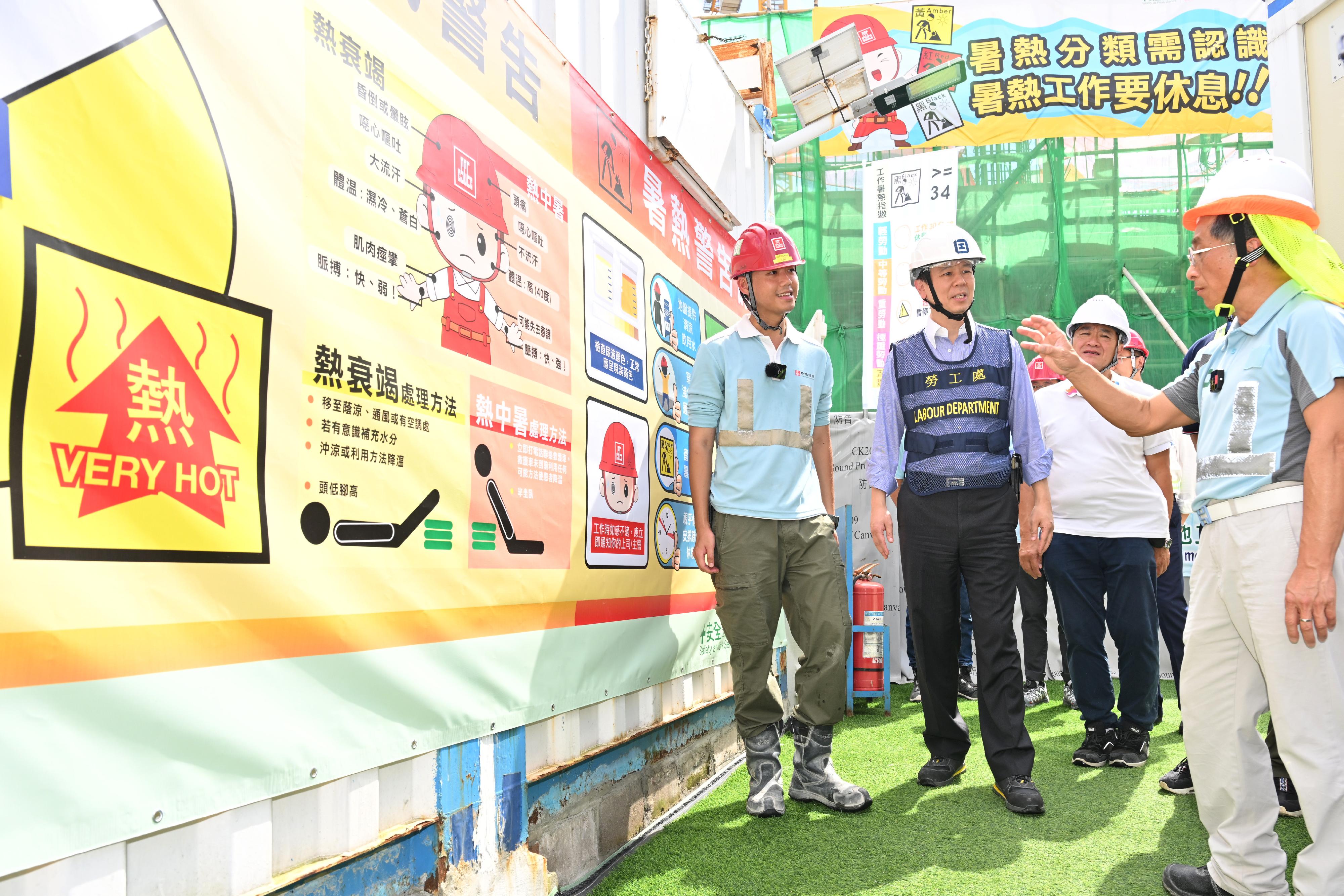 The Labour Department and representatives of the construction industry promoted prevention of heat stroke at work at a public works site in Tseung Kwan O today (June 9). Photo shows the Acting Commissioner for Labour, Mr Vincent Fung (second left); the Chairman of the Construction Industry Council, Mr Thomas Ho (first right); and member of the Construction Industry Council and Chairman of the Hong Kong Construction Sub-contractor Association, Mr Chan Kim-kwong (second right), being briefed by staff on heat stroke preventive measures at the construction site.
