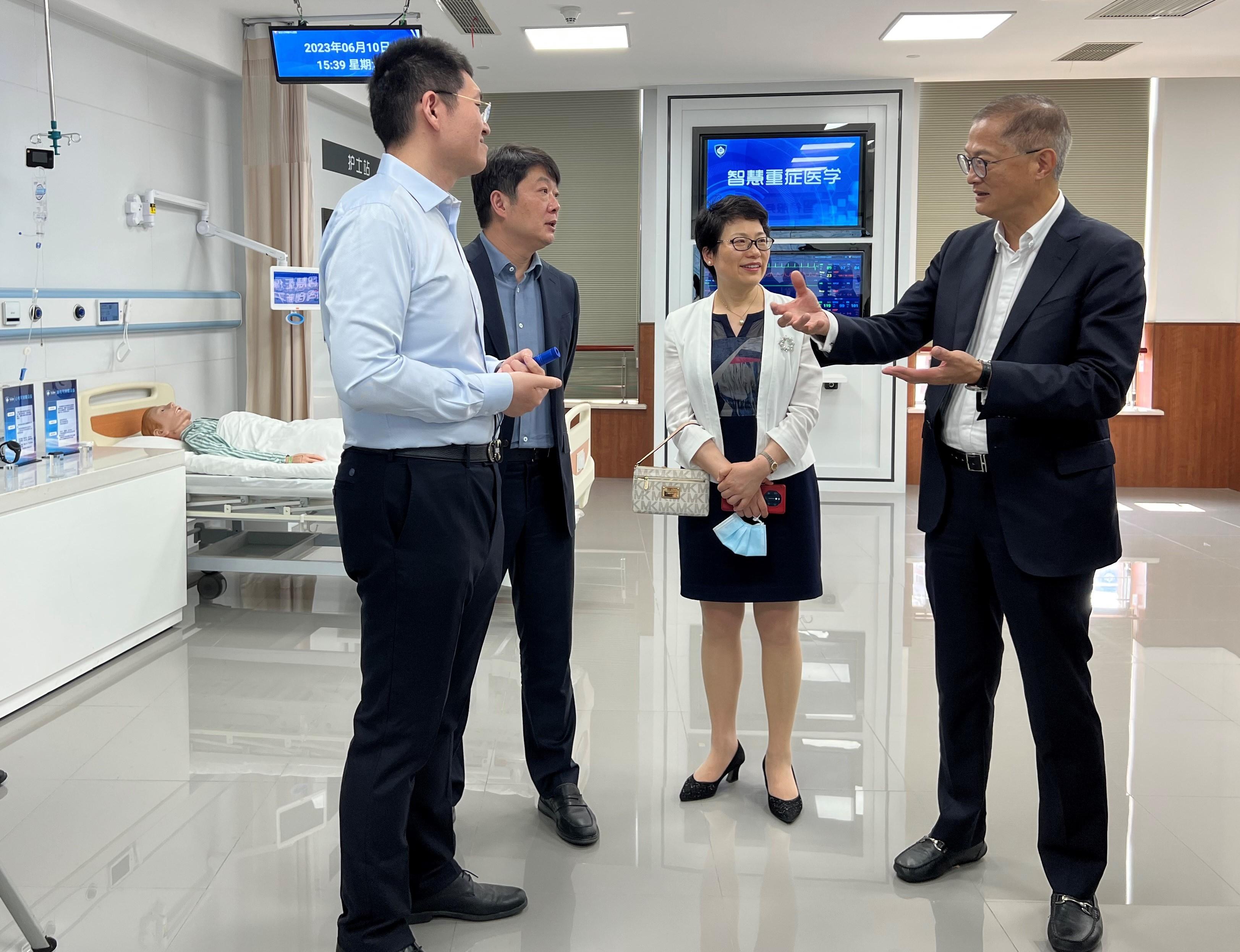 The Secretary for Health, Professor Lo Chung-mau (first right), toured the Exhibition Centre on Smart Healthcare of Zhongshan Hospital affiliated to Fudan University today (June 10) to learn about the hospital’s effort in enhancing treatment quality and user experience for patients through the operation as a smart hospital. Next to him are Deputy Director of the Shanghai Municipal Health Commission Mr Yu Tao (third right) and Vice President of the hospital Dr Gu Jianying (second right).