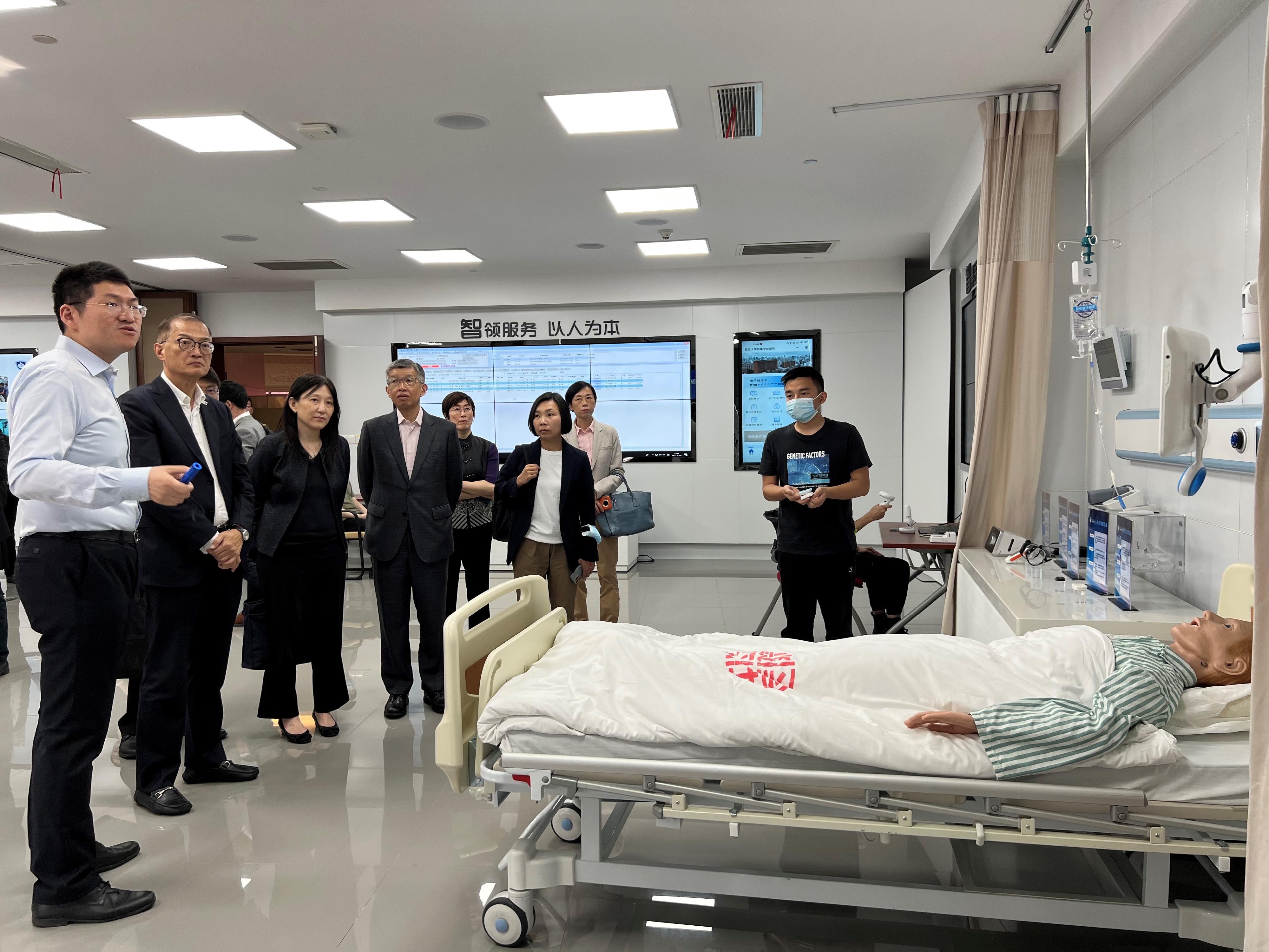 The Secretary for Health, Professor Lo Chung-mau (second left), toured the Exhibition Centre on Smart Healthcare of Zhongshan Hospital affiliated to Fudan University today (June 10) to learn about the hospital's effort in enhancing treatment quality and user experience for patients through the operation as a smart hospital. Looking on is the Director of Cluster Services of the Hospital Authority, Dr Simon Tang (fourth left).