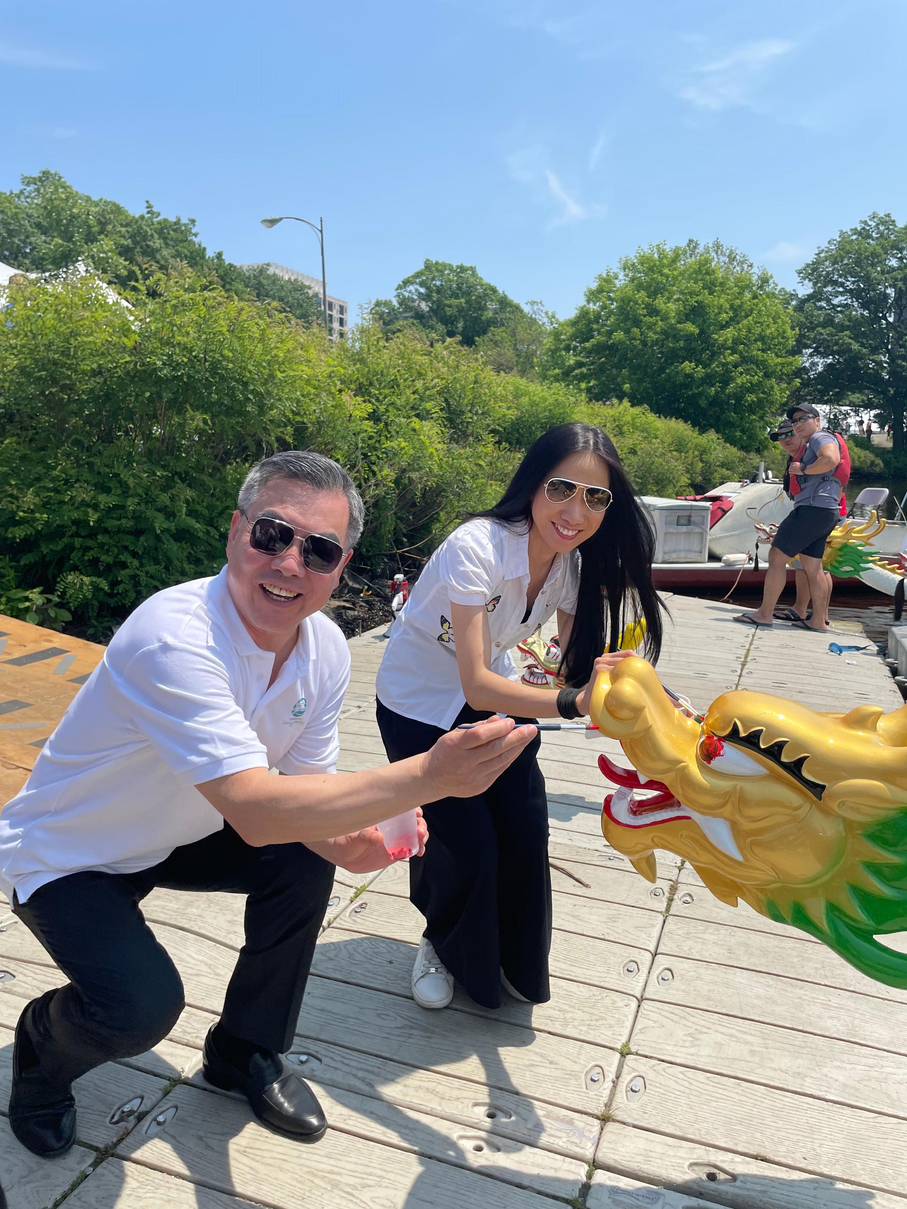 The 44th Boston Hong Kong Dragon Boat Festival was held today (June 11, Boston time). Picture shows the Director of the Hong Kong Economic and Trade Office in New York, Ms Candy Nip (right), with the Consul General of the People's Republic of China in New York, Ambassador Huang Ping (left), dotting the eyes of the newly commissioned Brand Hong Kong dragonboat.